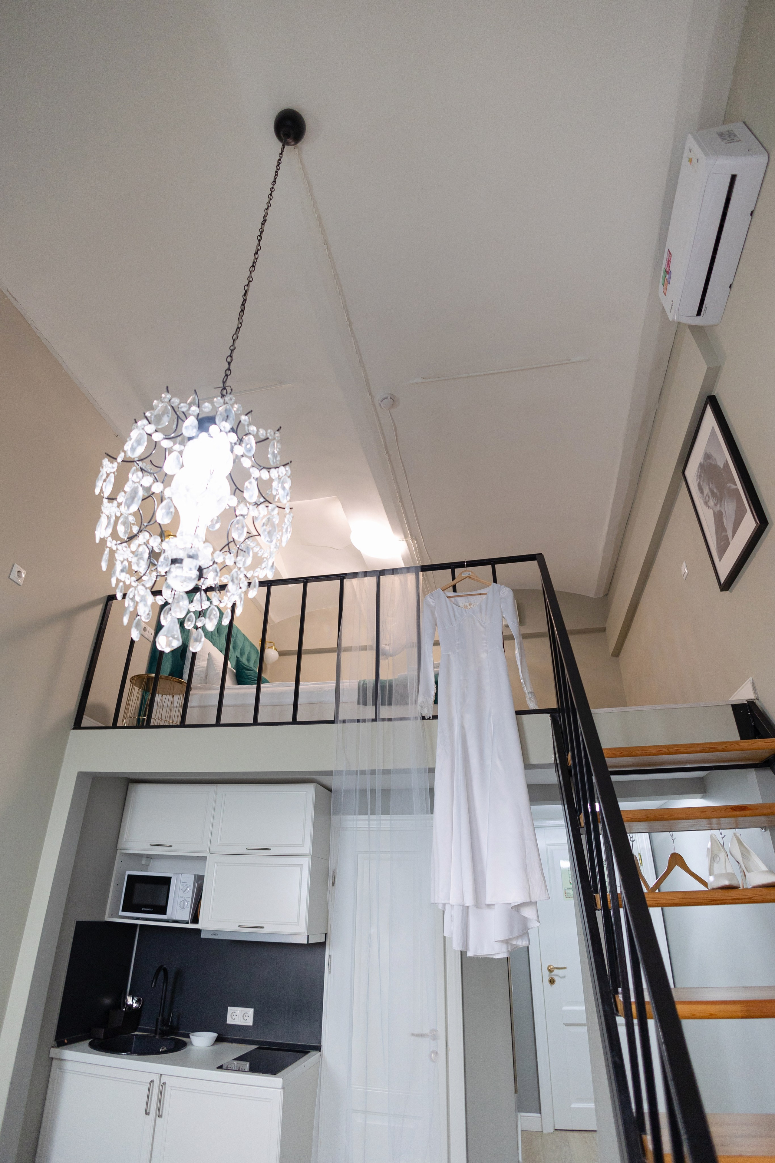 Белоснежное платье невесты в ожидании невесты на тремпеле на перилах лестницы.