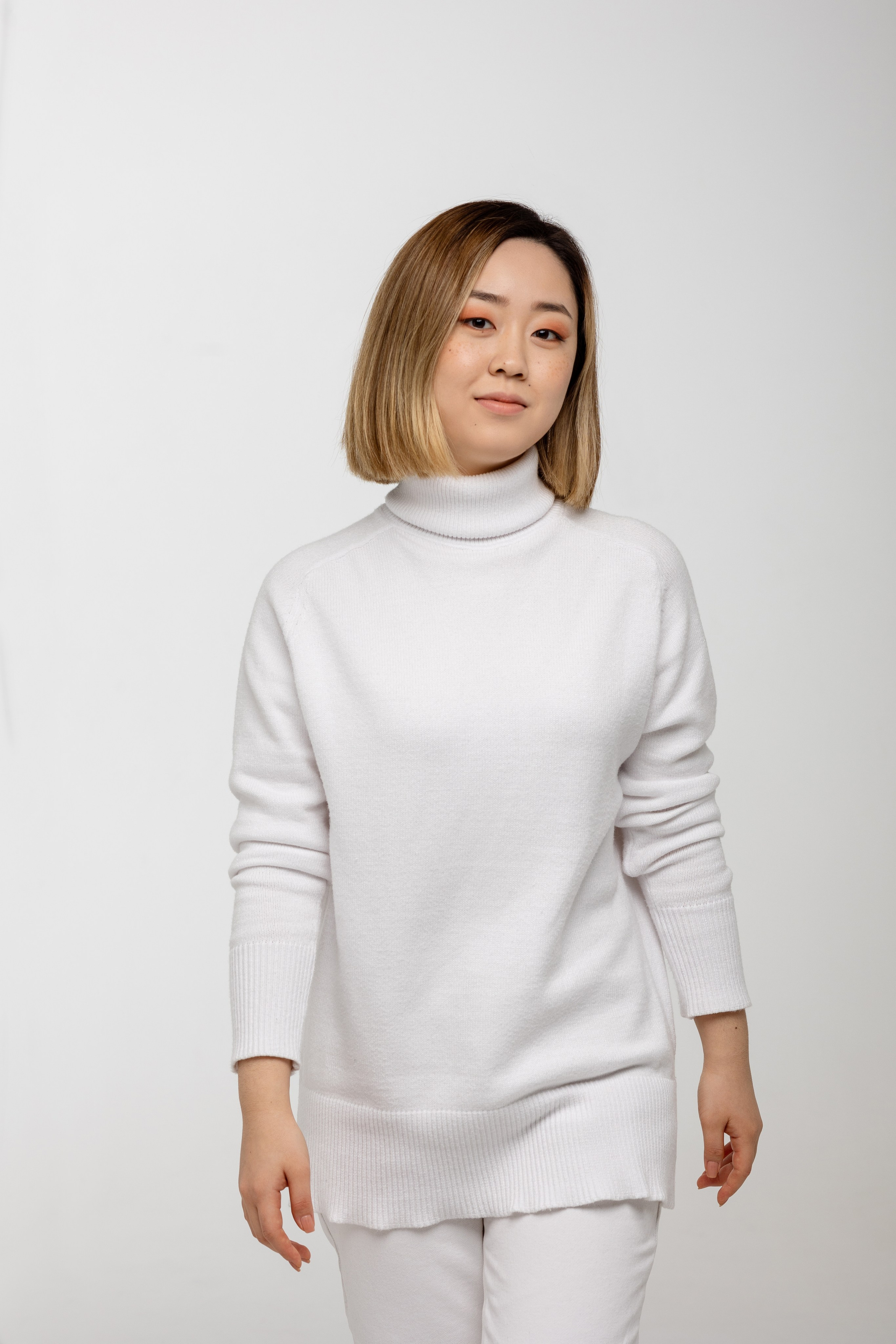 Девушка в белом костюме в движении на голубом фоне.