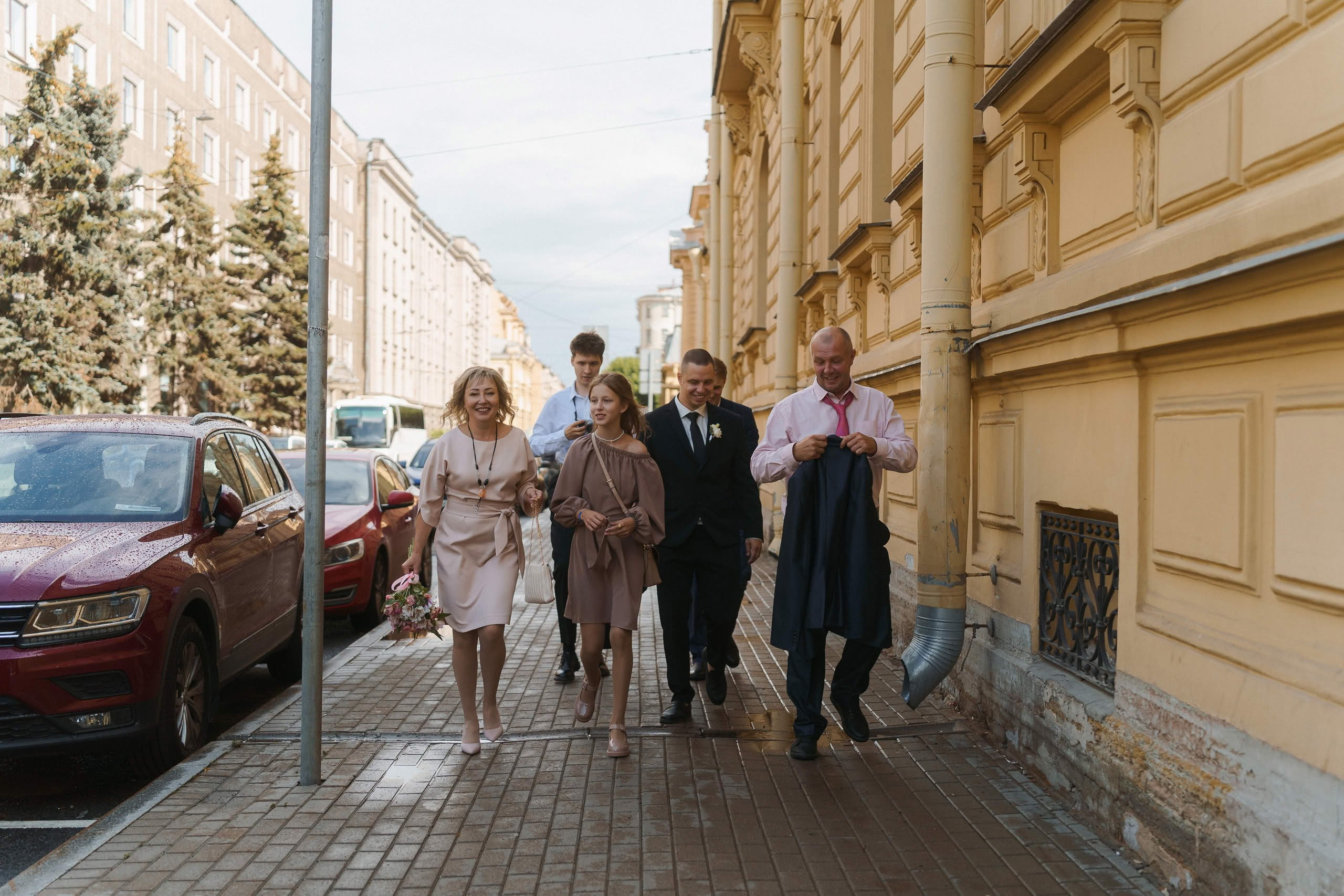 Свадебные гости идут по улице к ЗАГСу Петроградского района