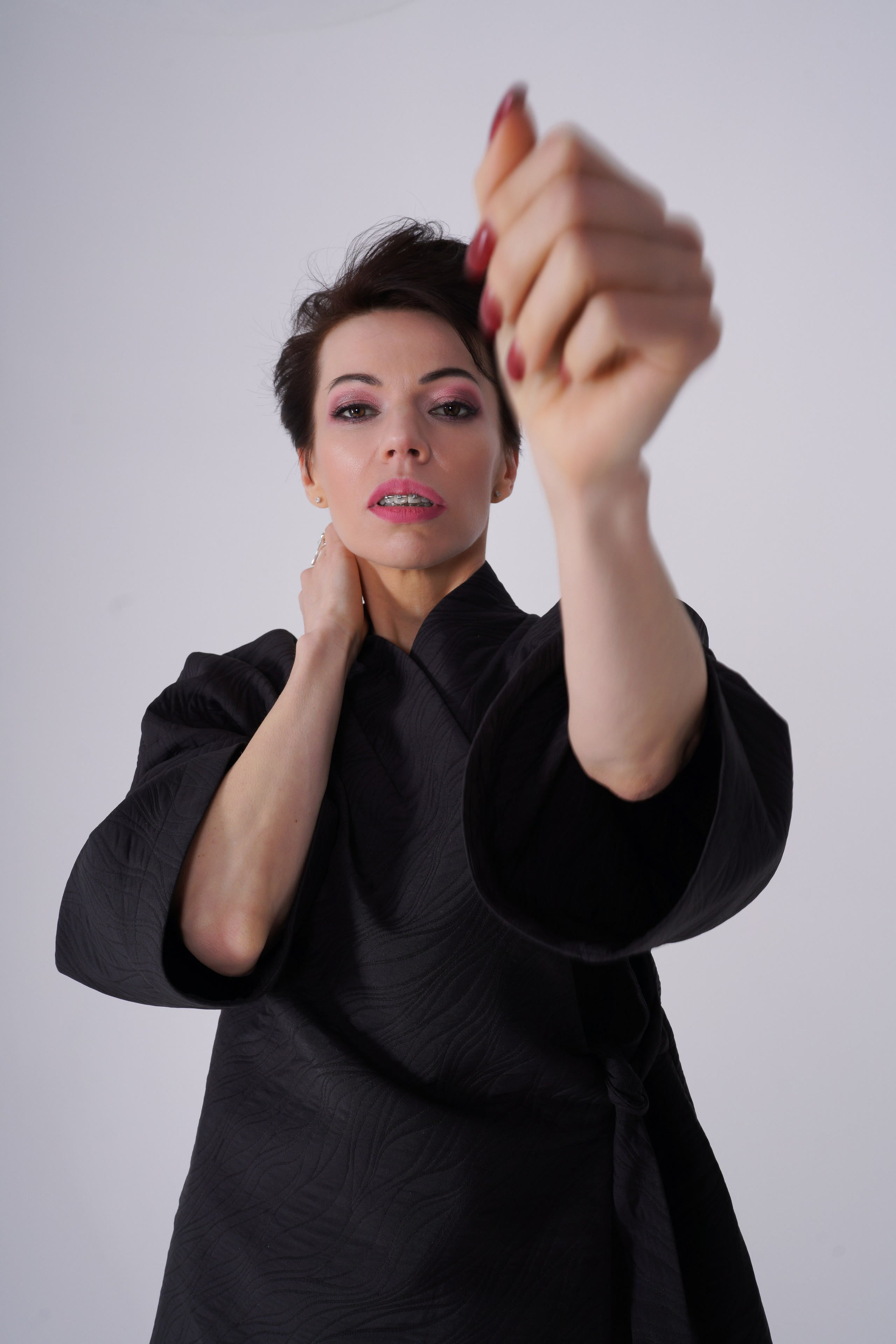 Девушка в кимоно тянет руку навстречу камере в руках фотографа