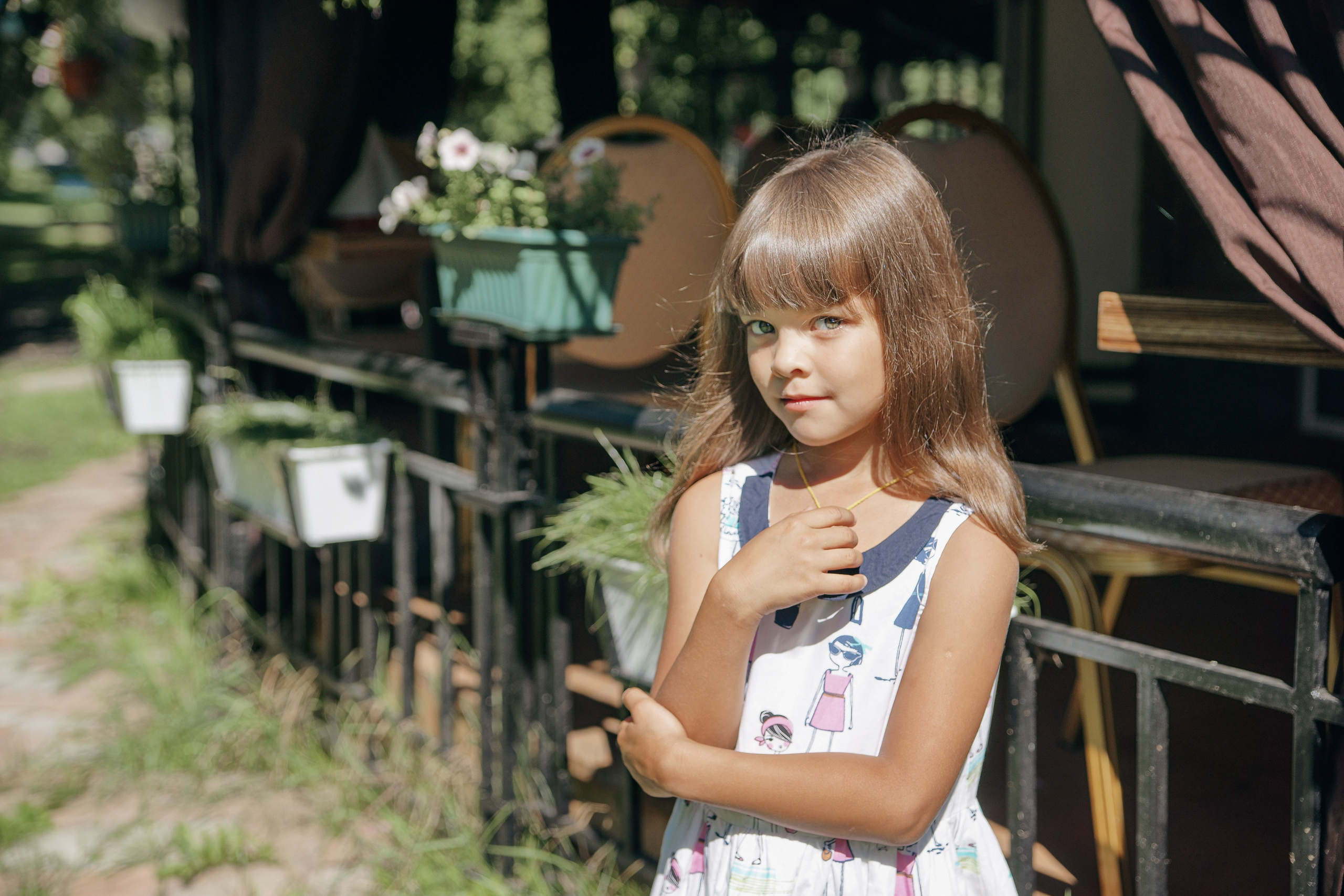 Детская фотосессия летом - девочка стоя у ограды