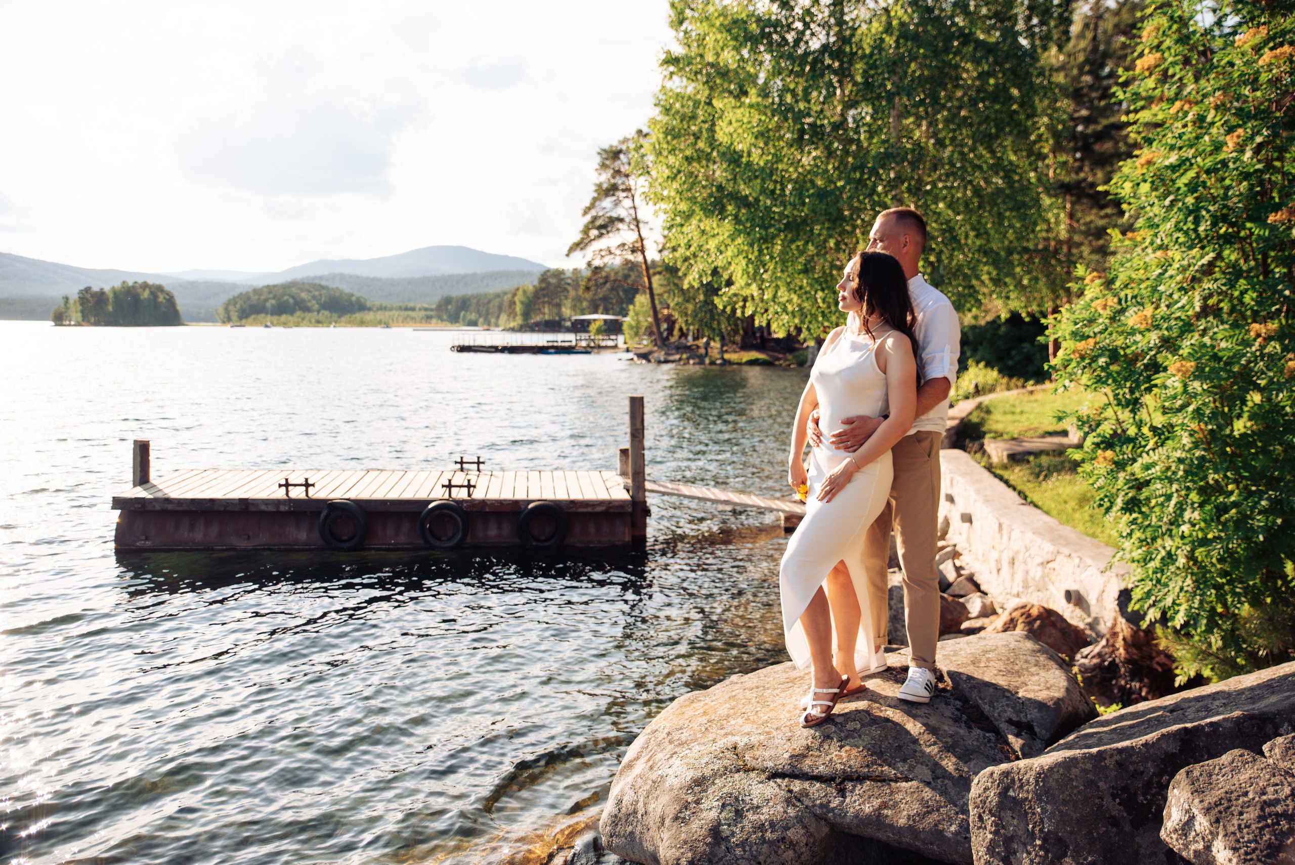 Семейная прогулка летом на берегу озера по пляжу