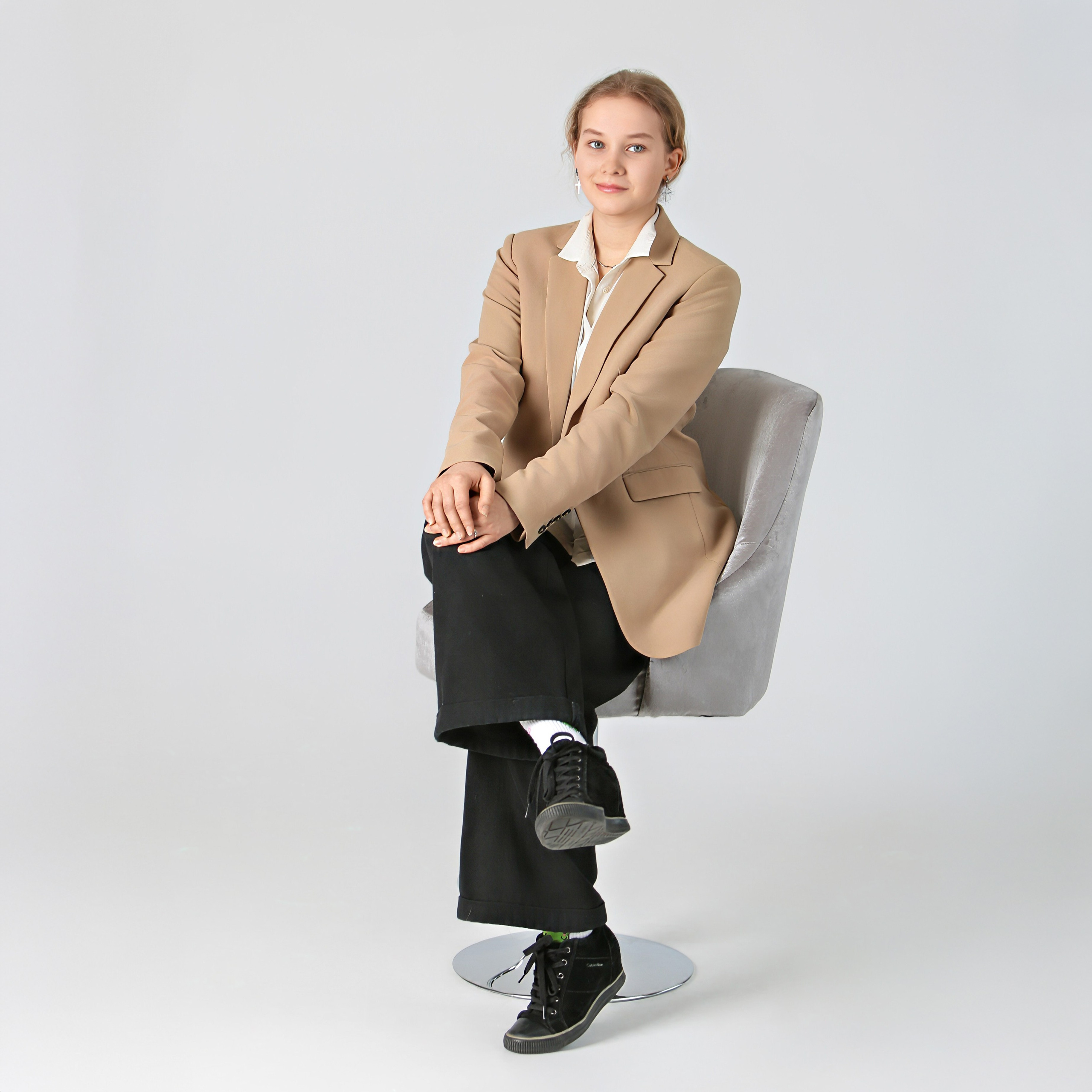 Девочка в бежевом пиджаке, сидит на стуле, школьная фотосессия