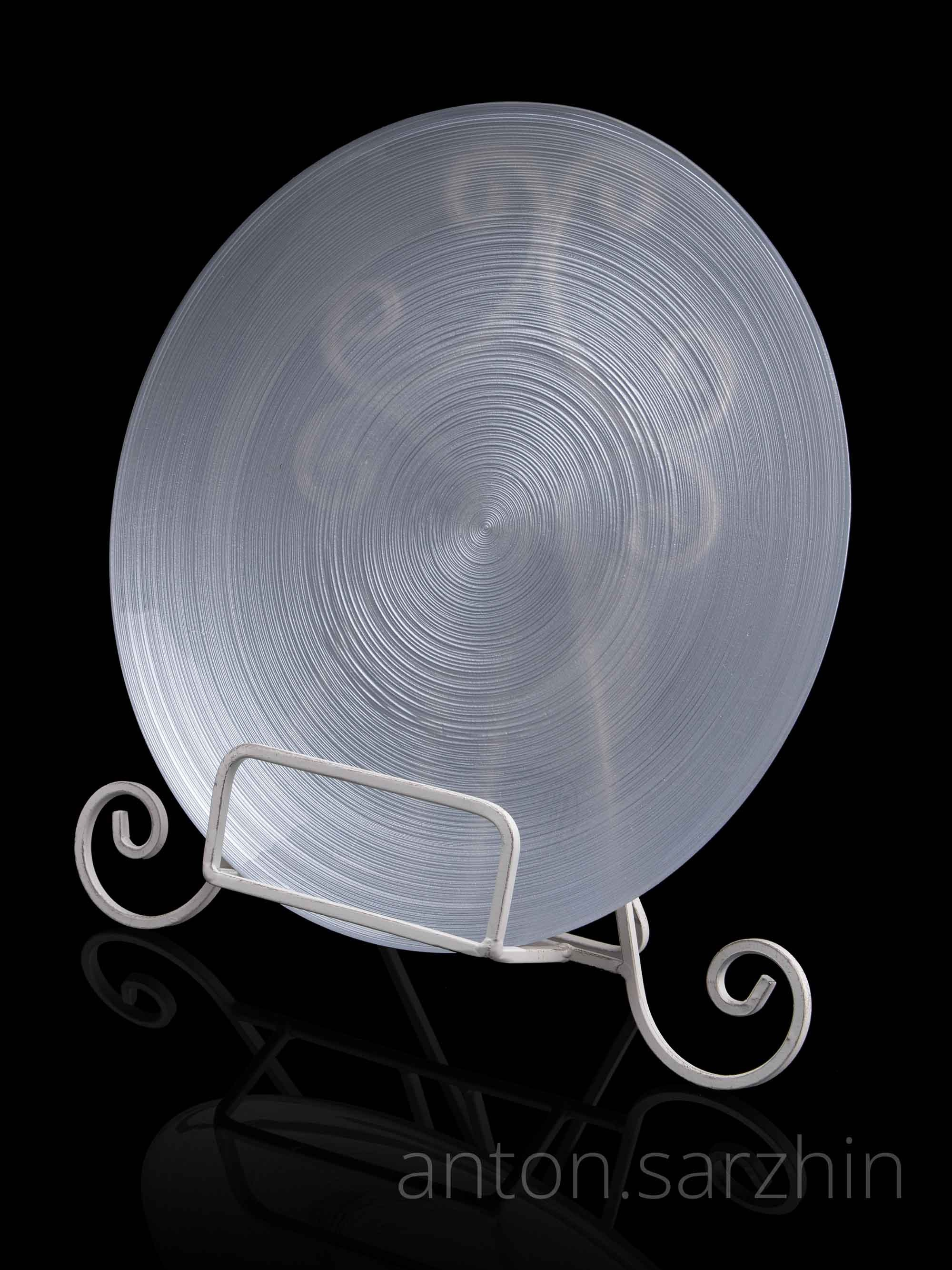 Предметная съемка блюда на подставке на черном фоне