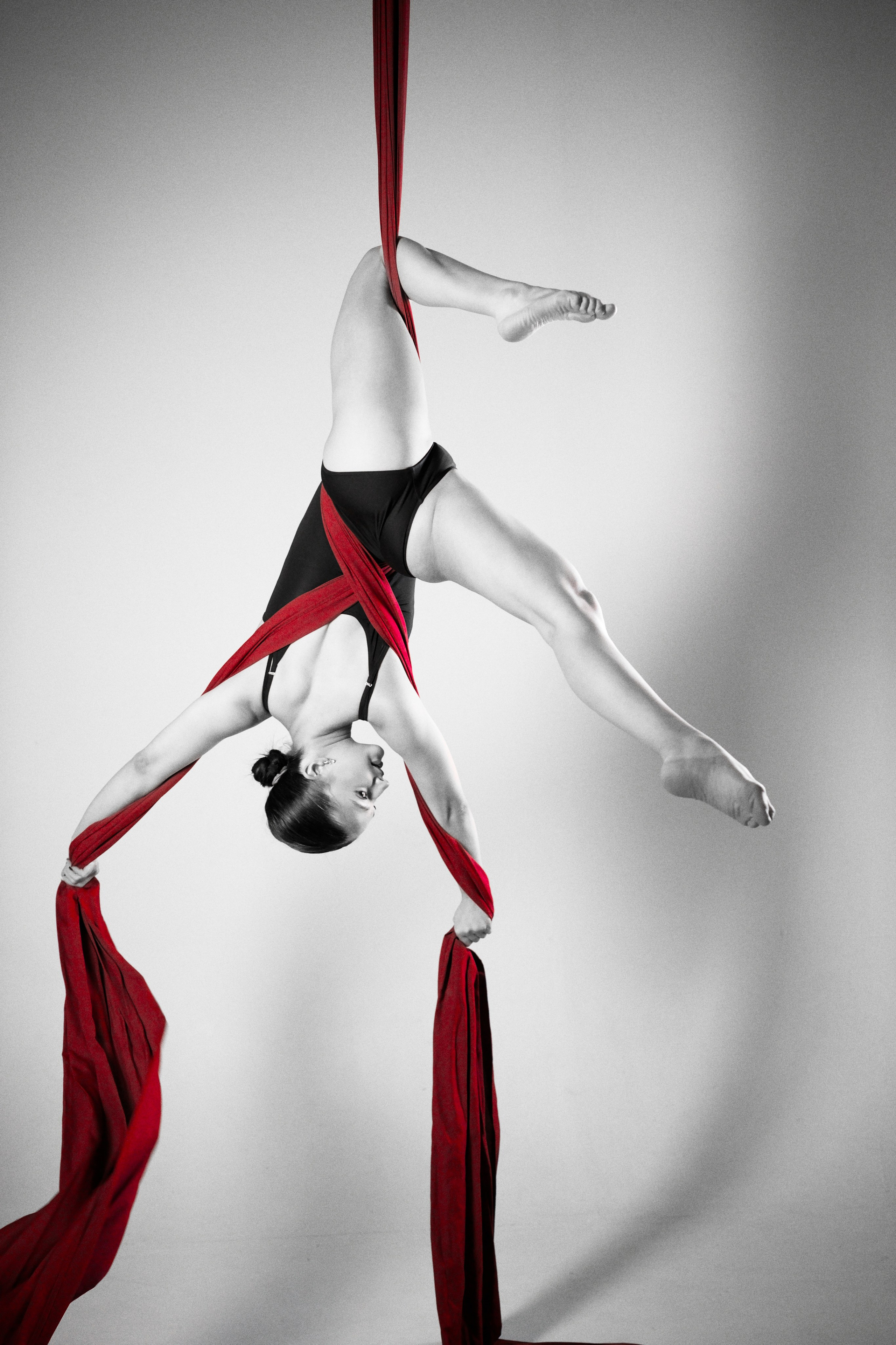 Сложный перевернутый элемент воздушной гимнастики на красных полотнах, профессиональная съемка в Тюмени
