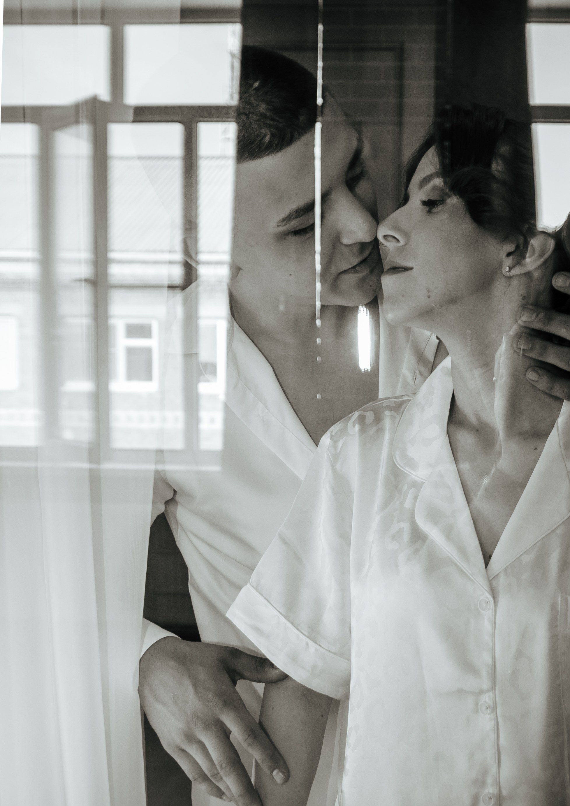 Красивая фотография на утренней фотосессии жених и невеста за стеклом в черно белой обработке от фотографа марина ковалёва