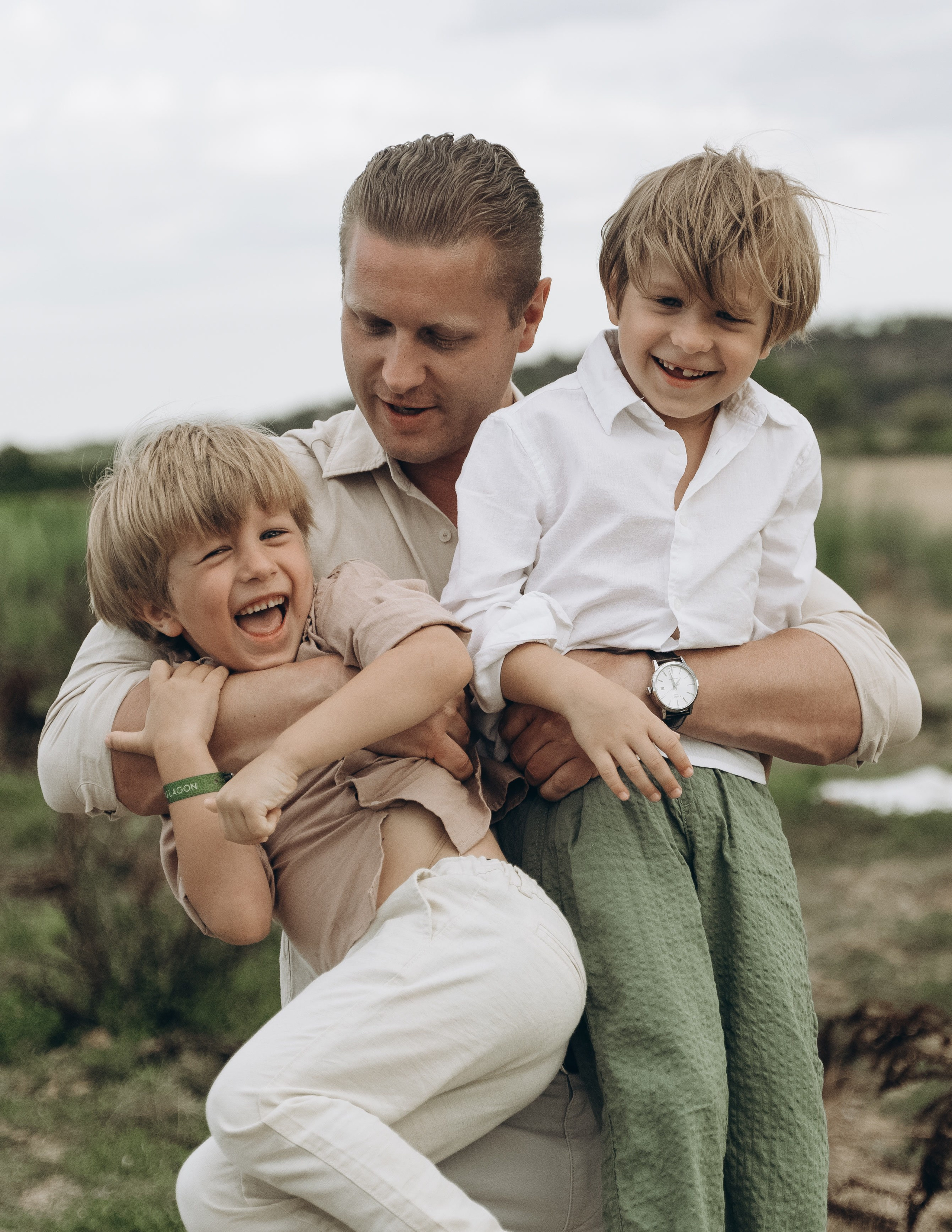 Papa et ses enfants assis dans l'herbe, moment complice en famille, Provence