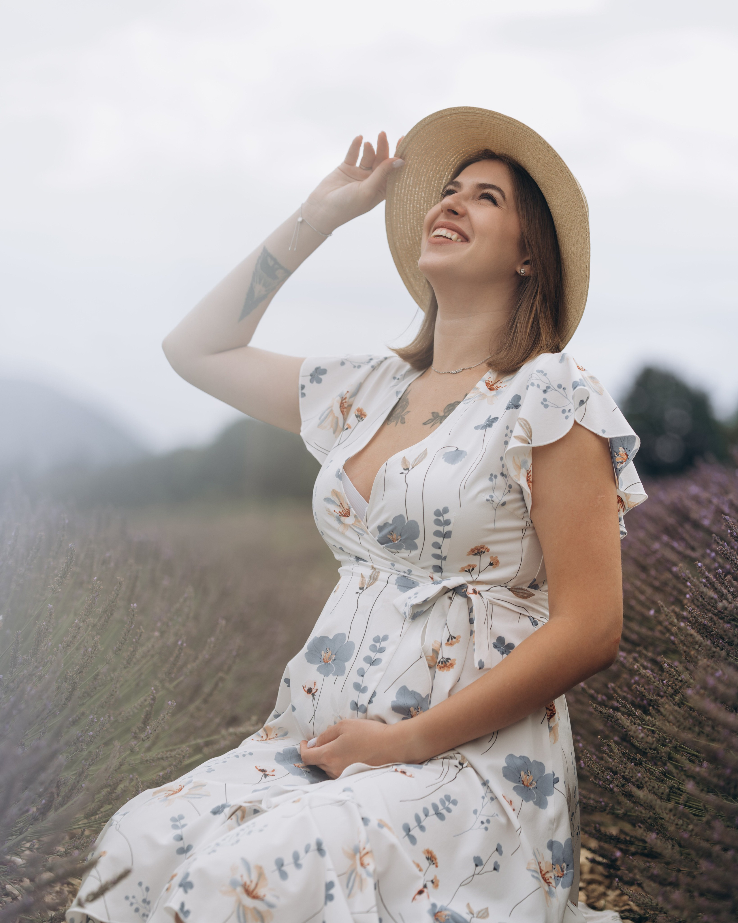 Femme enceinte assise dans un champ de lavande, séance grossesse en Provence