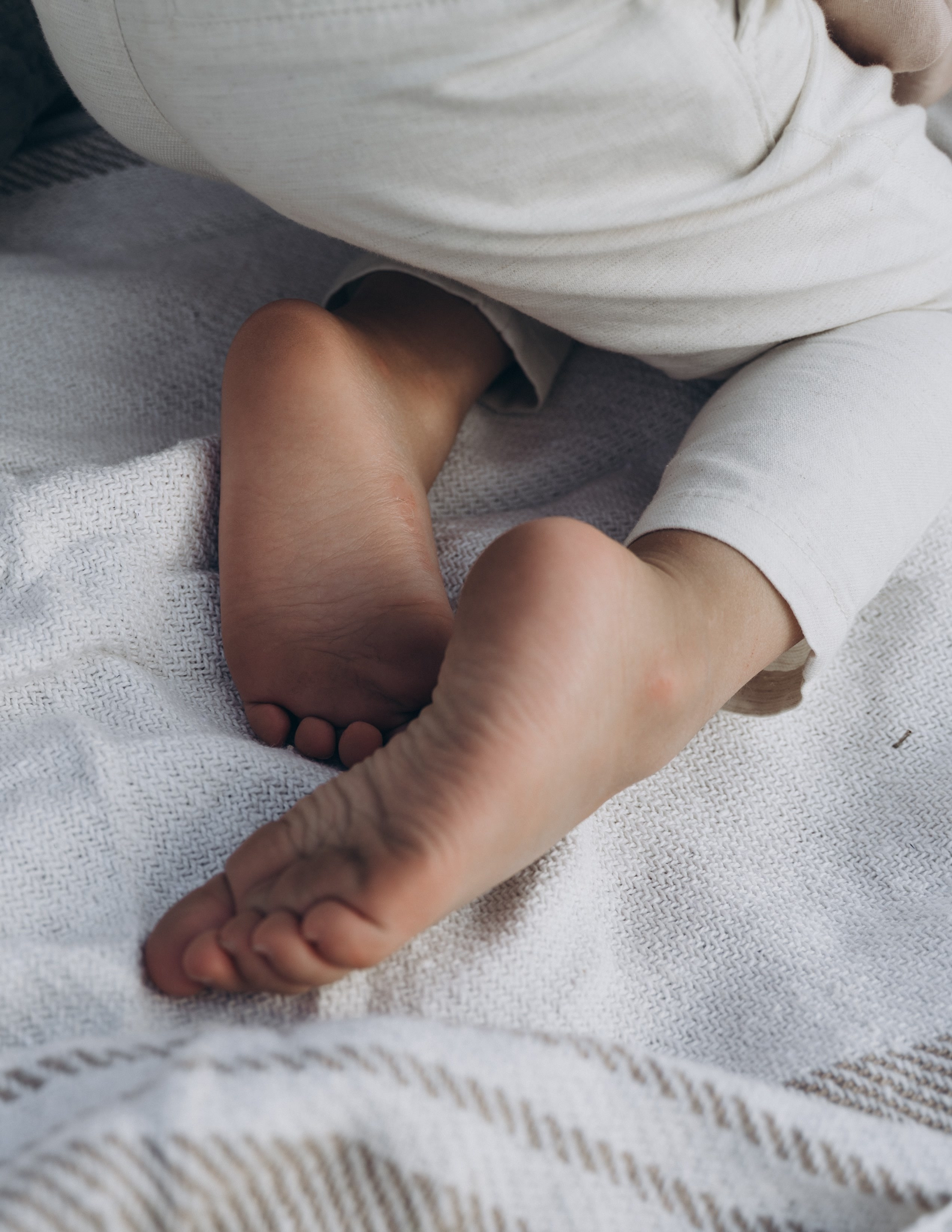 Pieds nus d'enfant sur une couverture, détail d'une séance famille en Provence