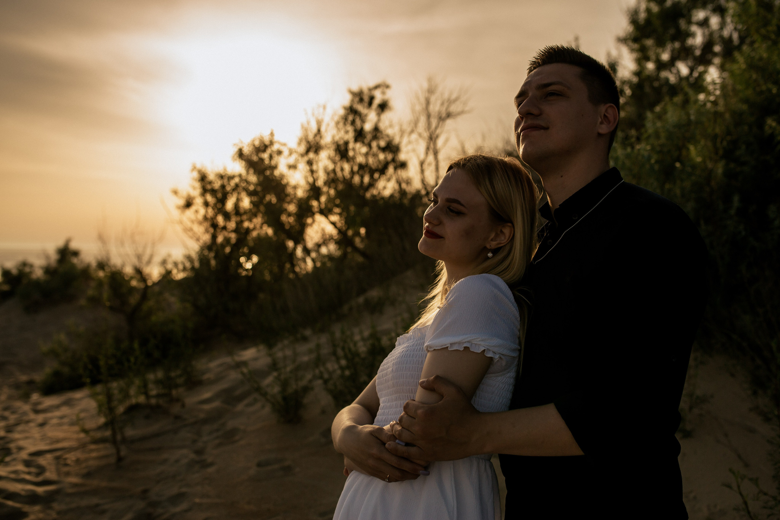 Жених и невеста смотрят вдаль на фоне закатного солнца в Джемете.