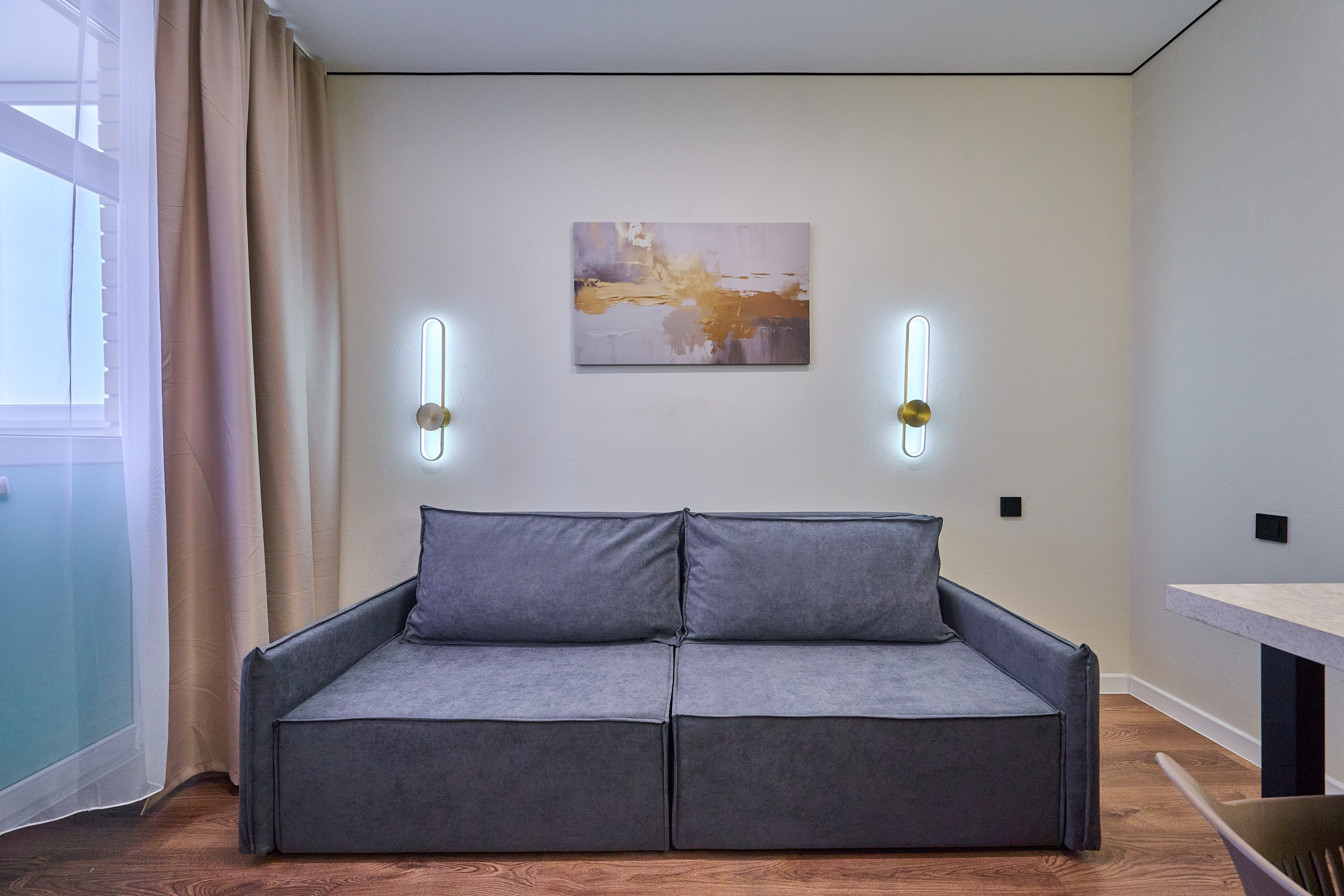 серый диван белые обои 