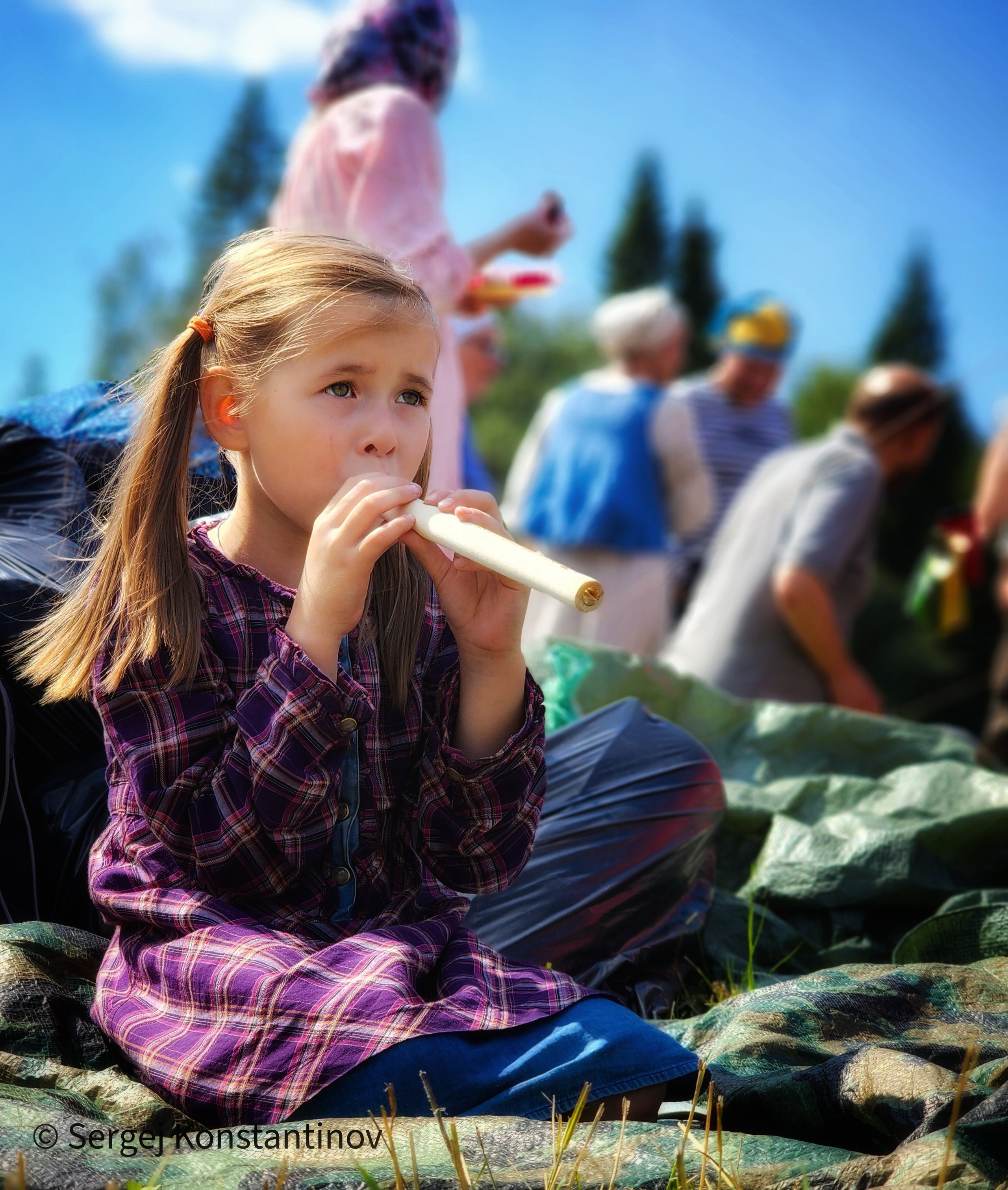 Девочка играет на дудочке репортажное фото