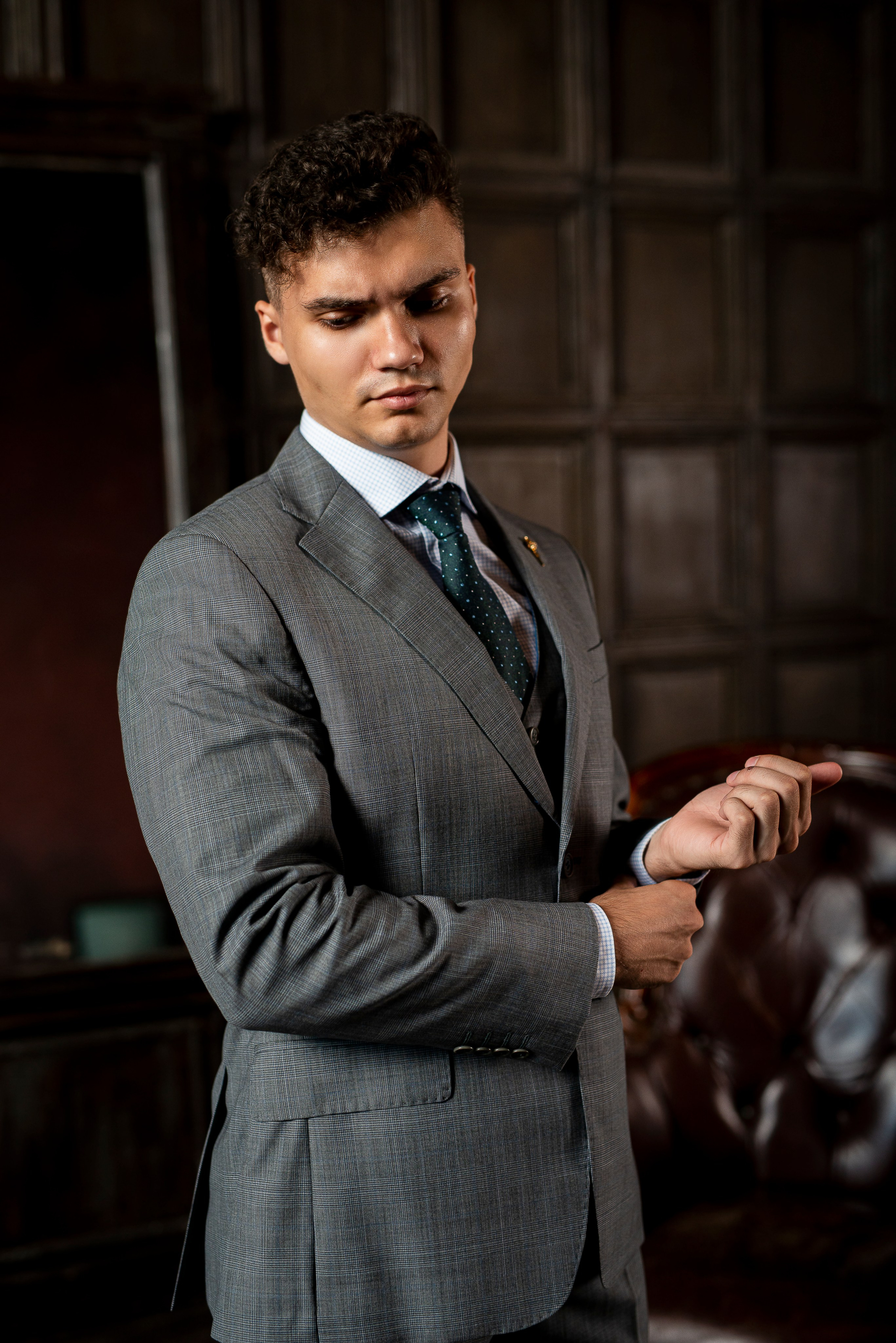 Фотография молодого человека, который позирует в фотостудии в деловом стиле