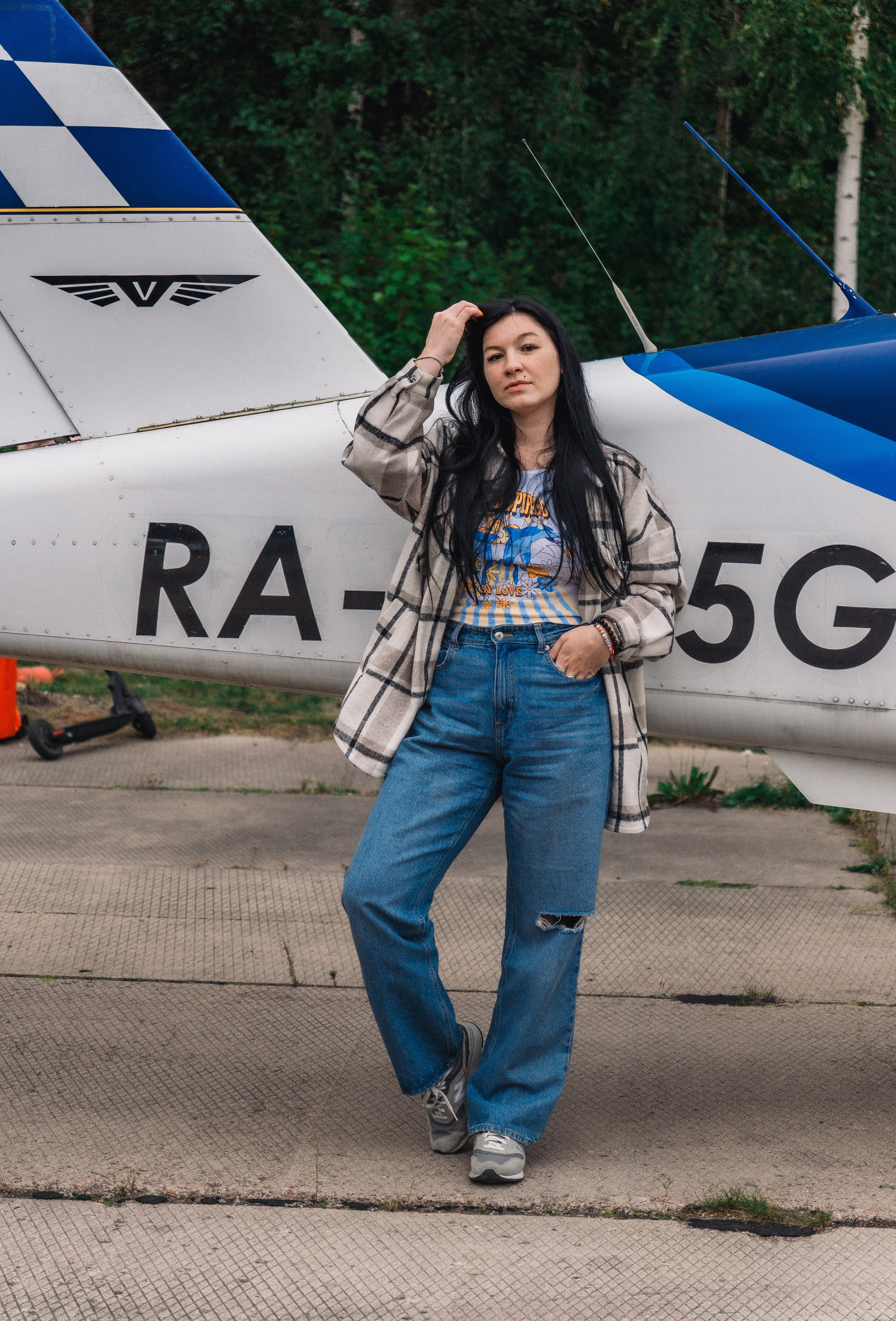 девушка позирует у самолета 