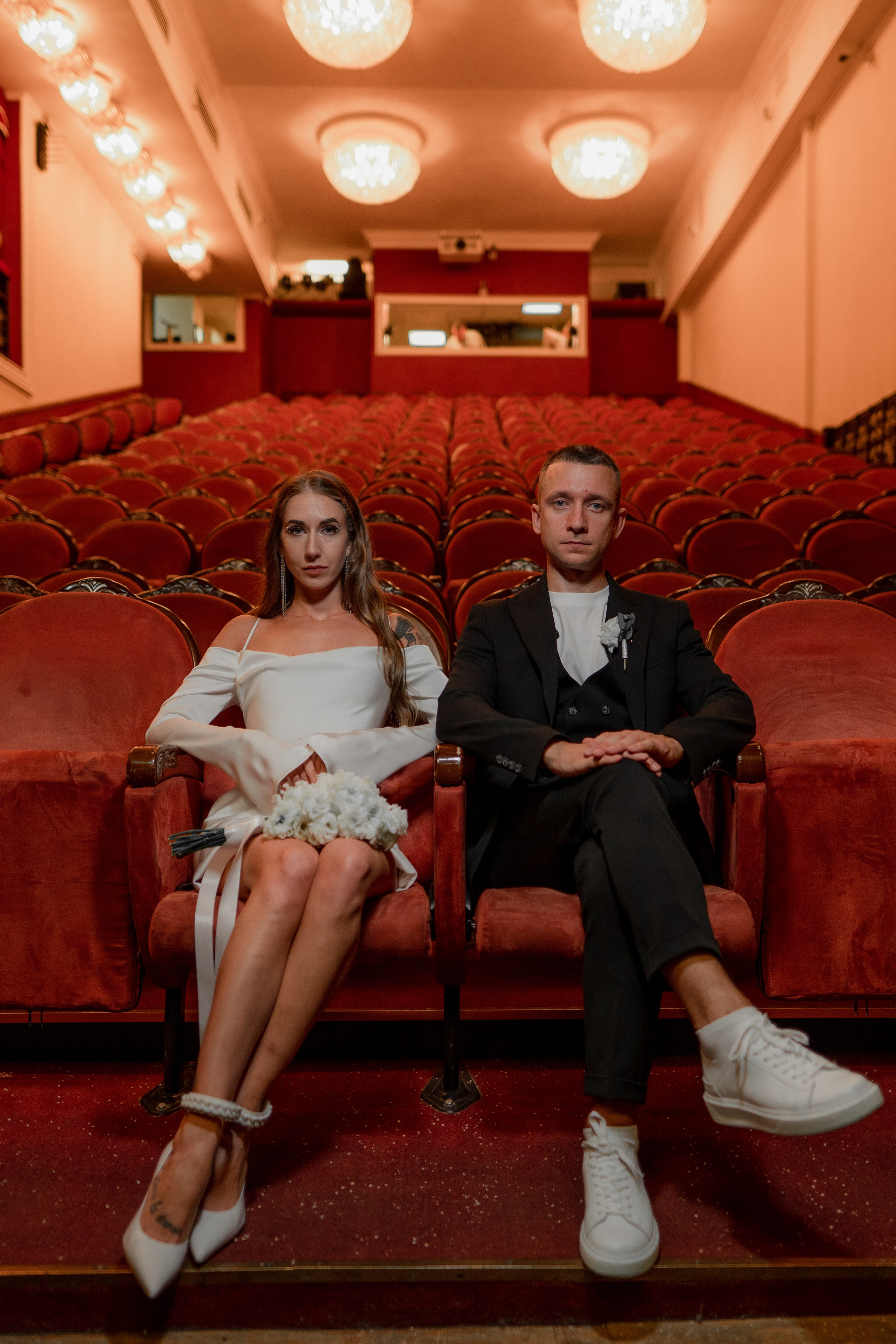 Невеста и жених сидят в пустом зале театра имени Андрея Миронова в Санкт-Петербурге