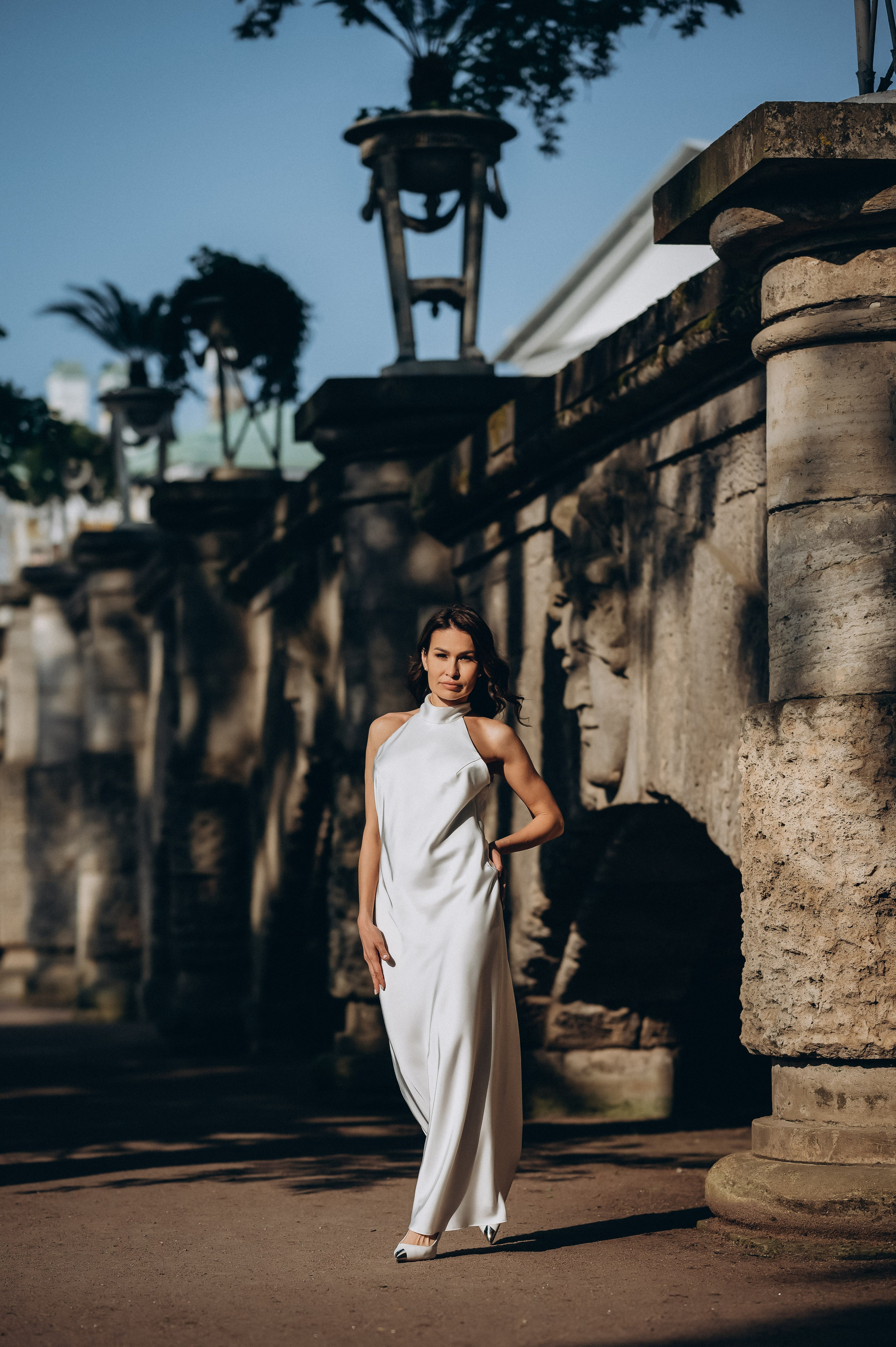 Сногсшибательная невеста элегантно идет по аллее в Екатерининском парке