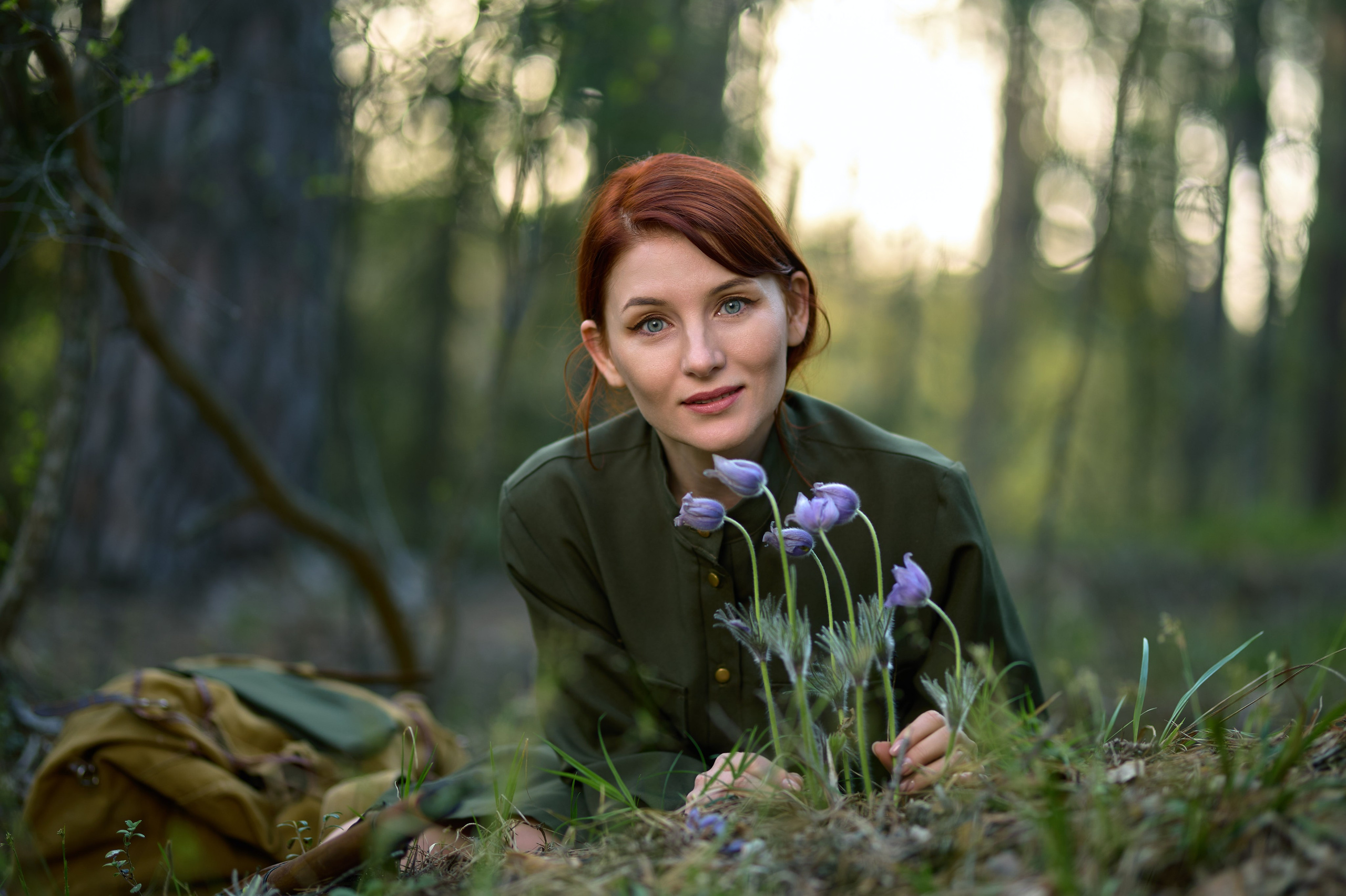 тематическая фотосессия на военную тему, девушка сидит с винтовкой в лесу около цветов