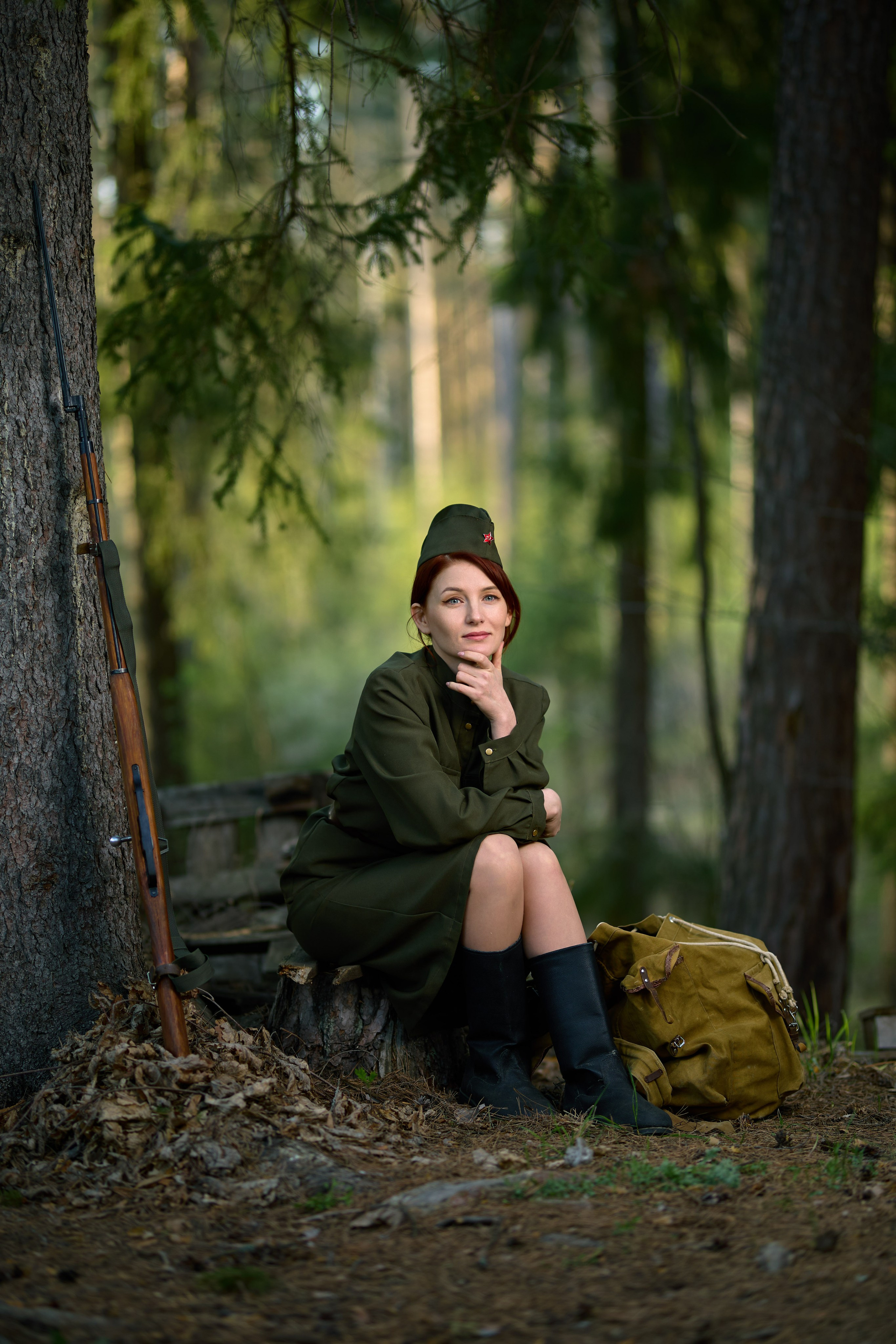 тематическая фотосессия на военную тему, девушка сидит с винтовкой в лесу