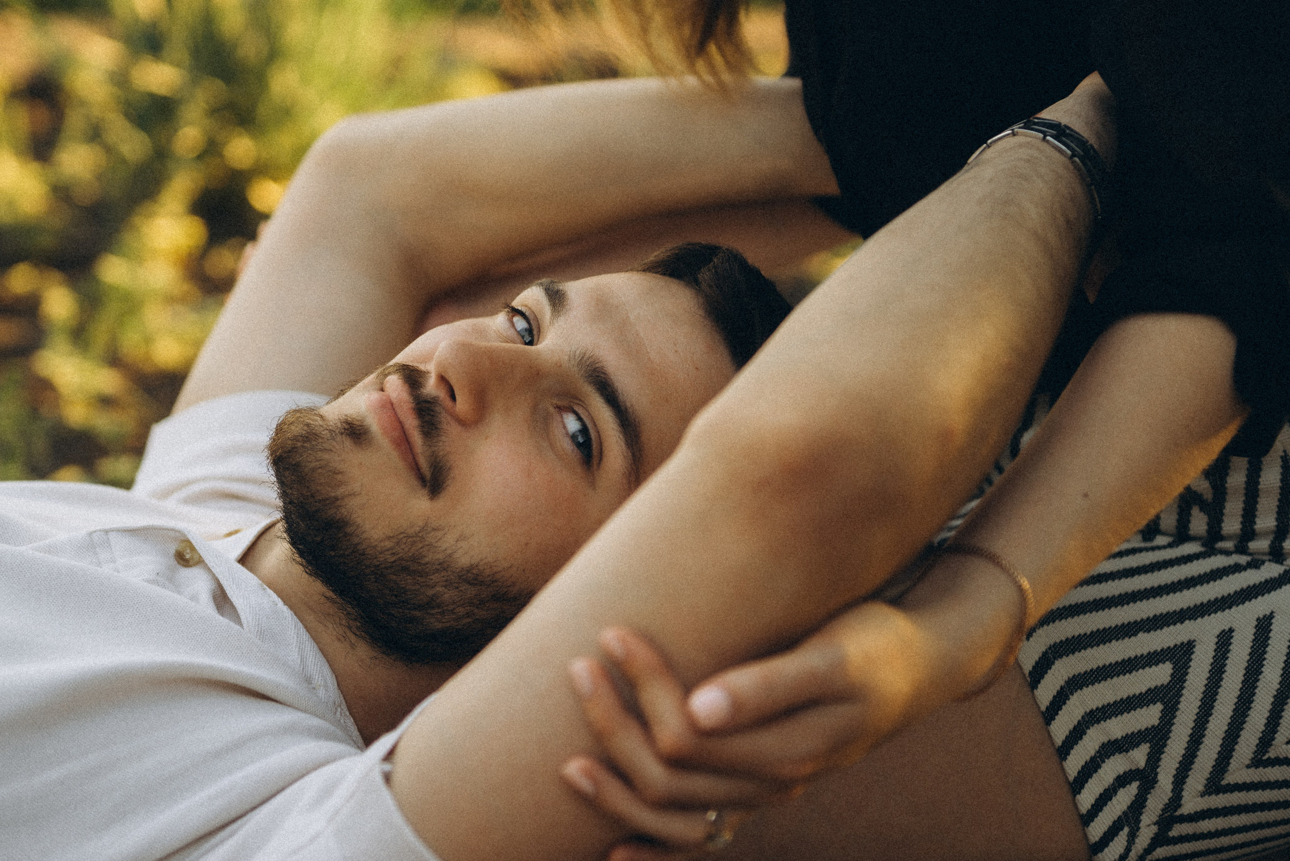 Крупный план: он лежит на её коленях, её руки обнимают его лицо. Теплый портрет с Love Story на набережной Новосибирска.