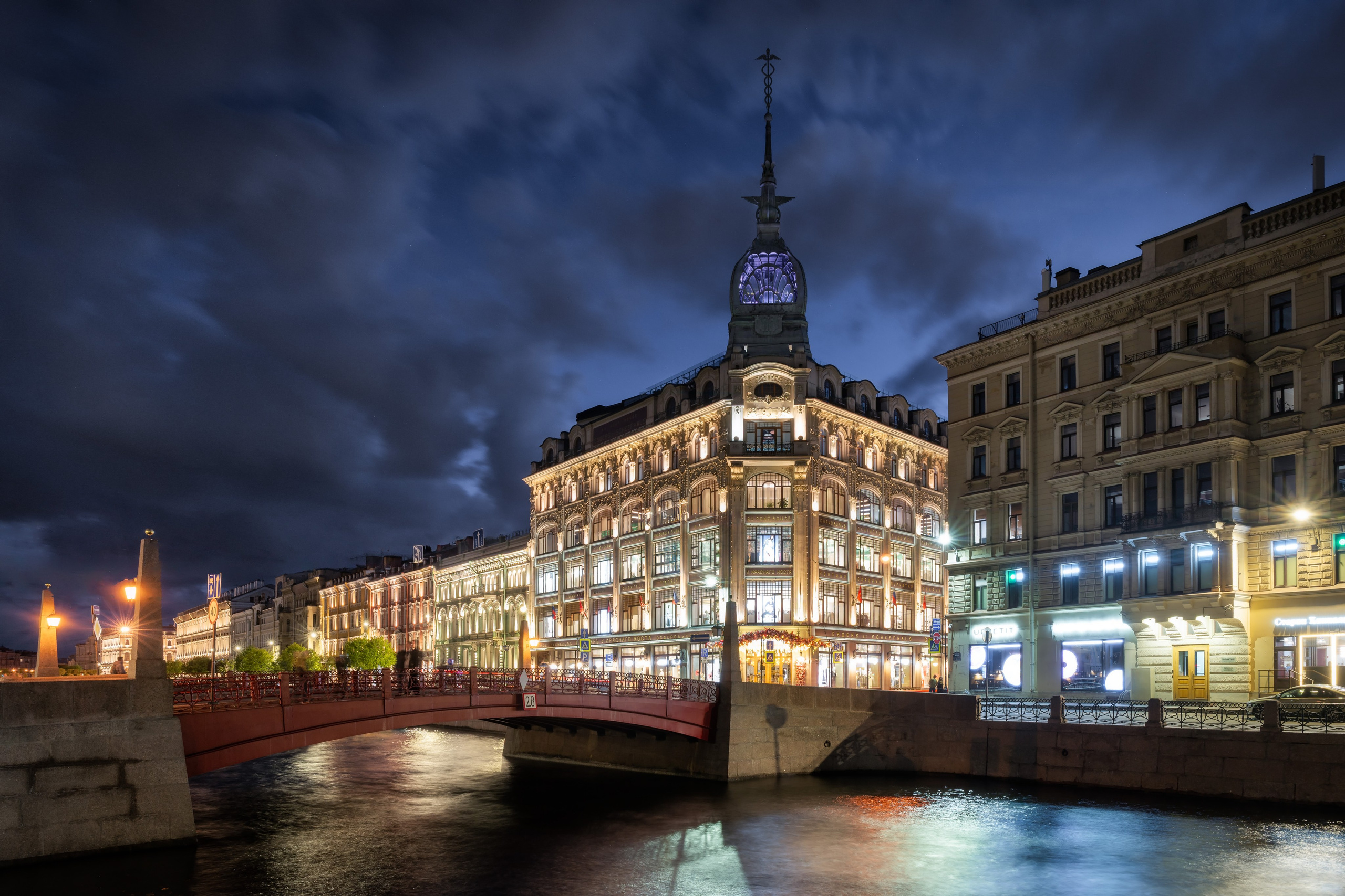 Вечерний вид на здание с куполом и мост через канал
