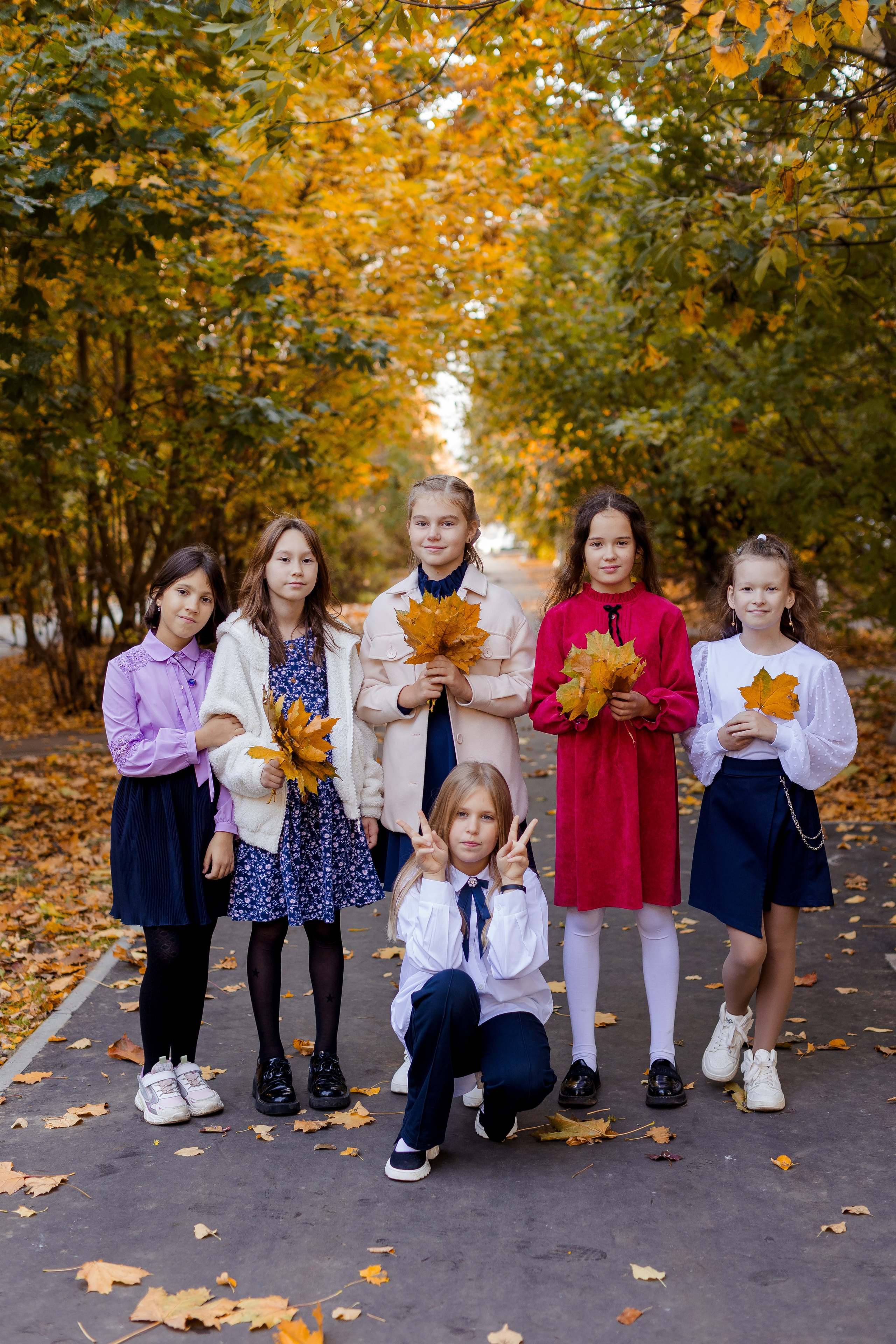 Девочки подружки фотографируются с осенними листочками
