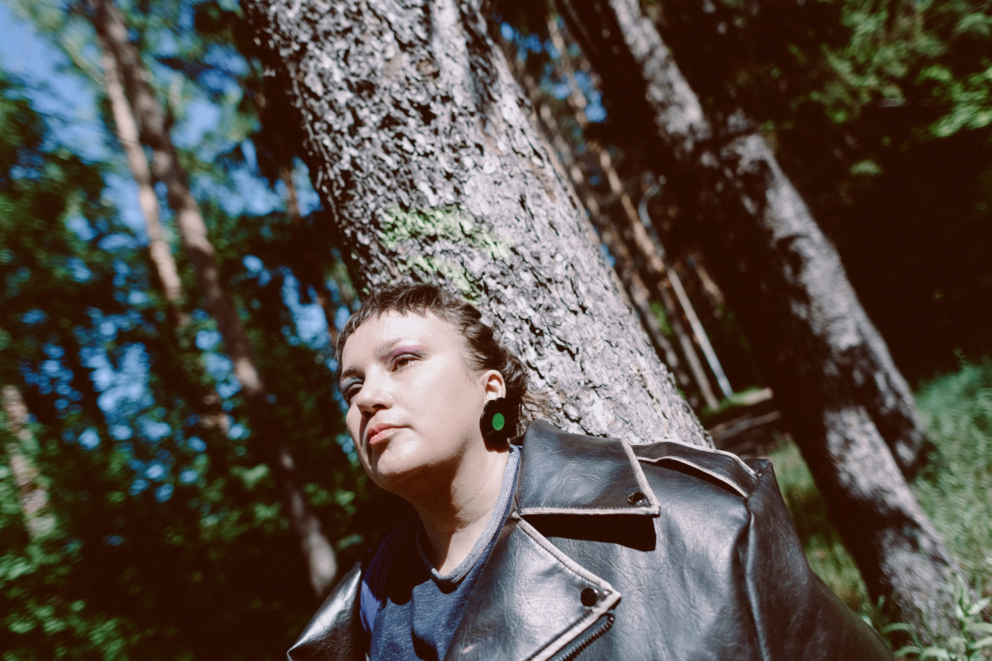 Задумчивый профиль девушки на фоне зелени, психологическая портретная съемка