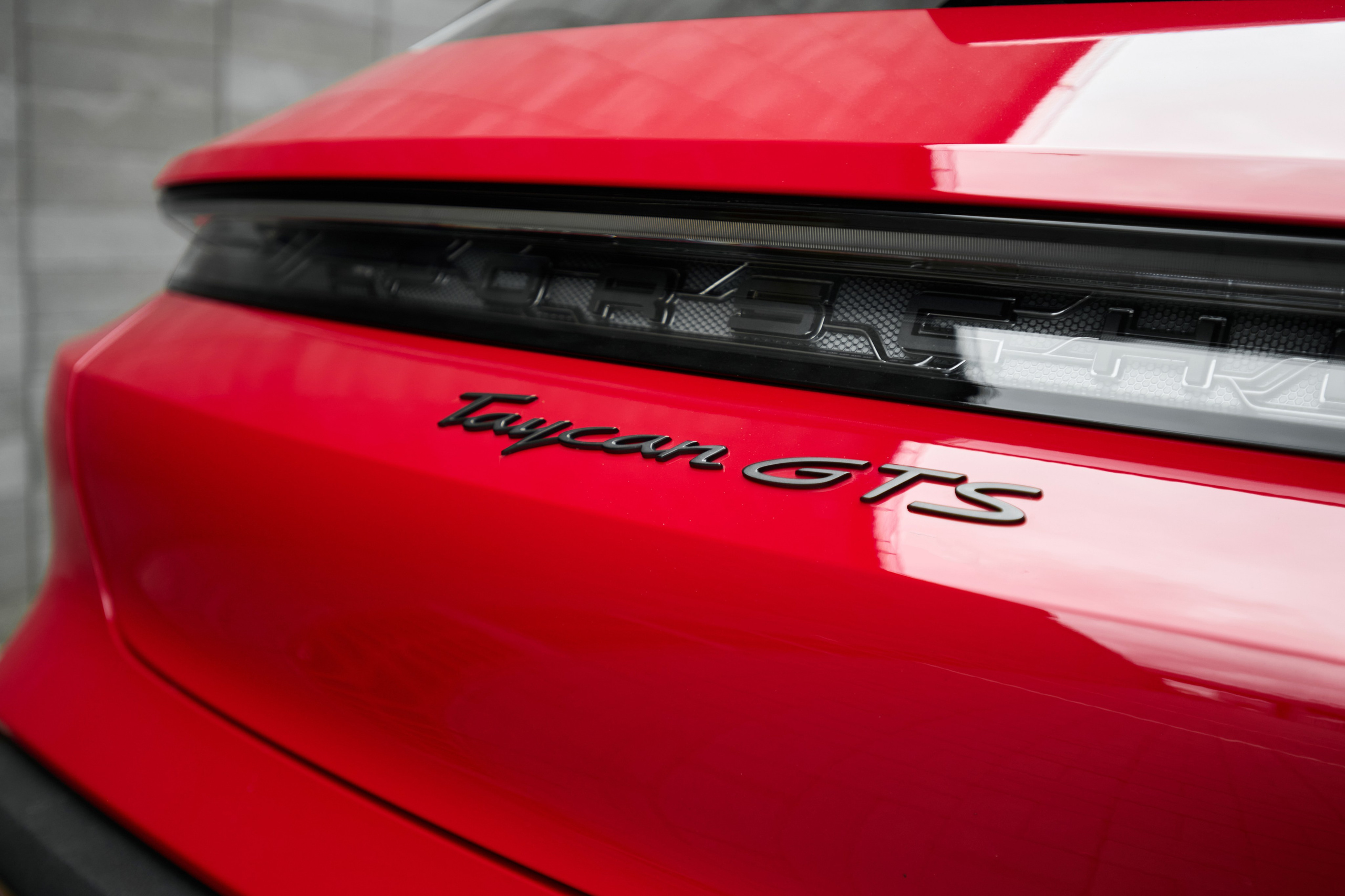 Шильдик Porsche Taycan GTS на задней части кузова крупным планом