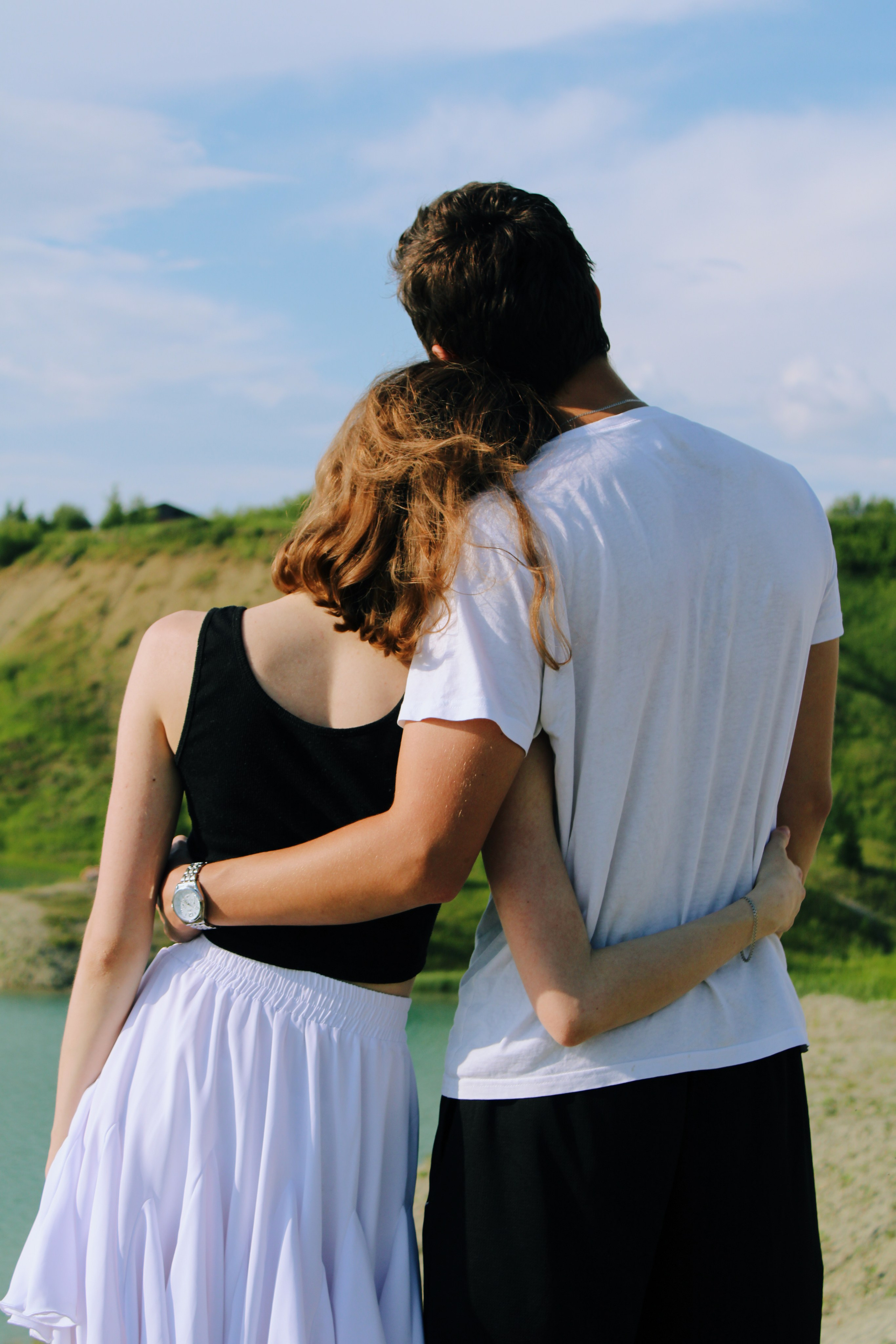 Парень и девушка. В обнимку стоят спиной к камере и смотрят вперед