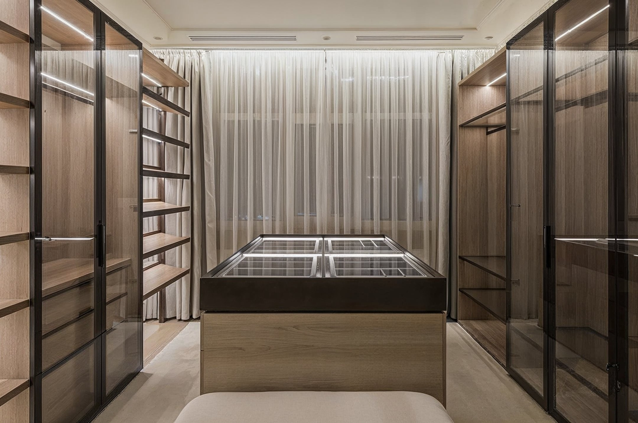 Светлая гардеробная комната с витринами и деревянными полками — интерьер Валерии Котович