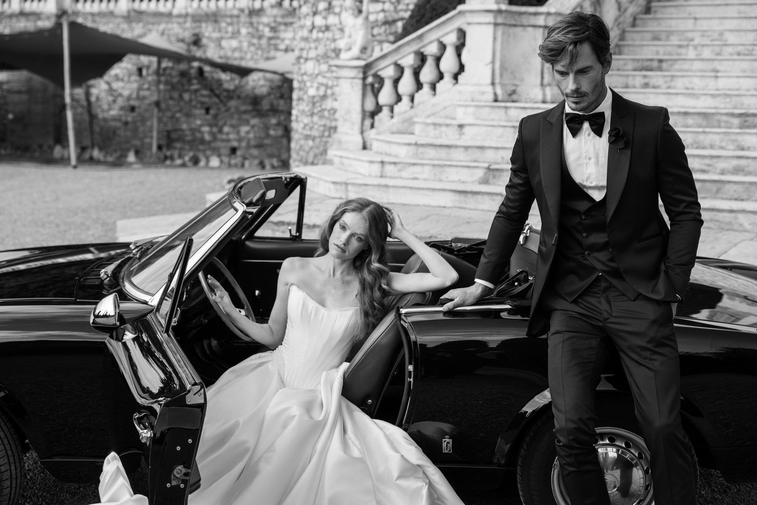 Elegant wedding portrait beside a luxury vintage car