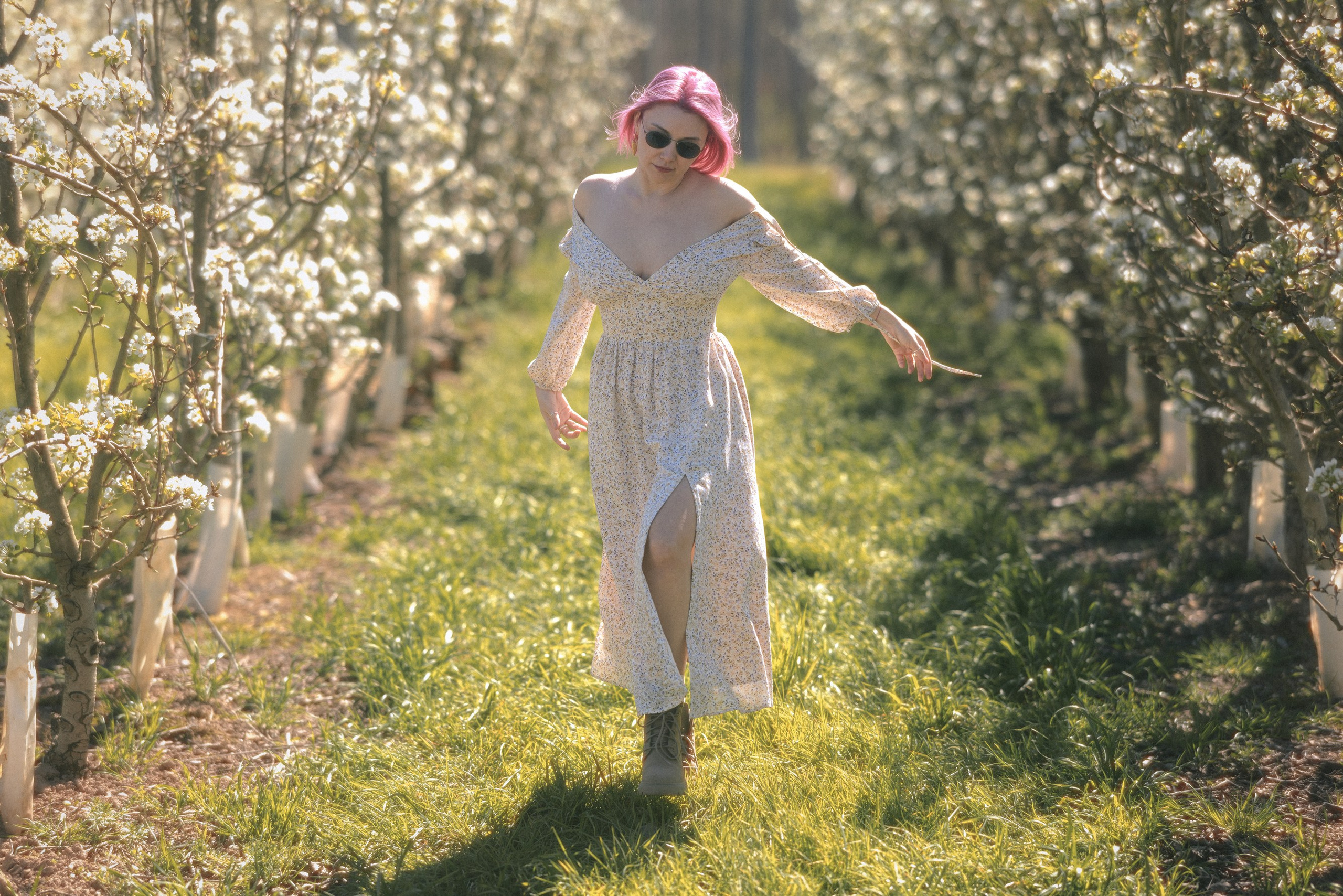 Woman in a light dress walking through a blooming park in Barcelona, artistic portrait photography