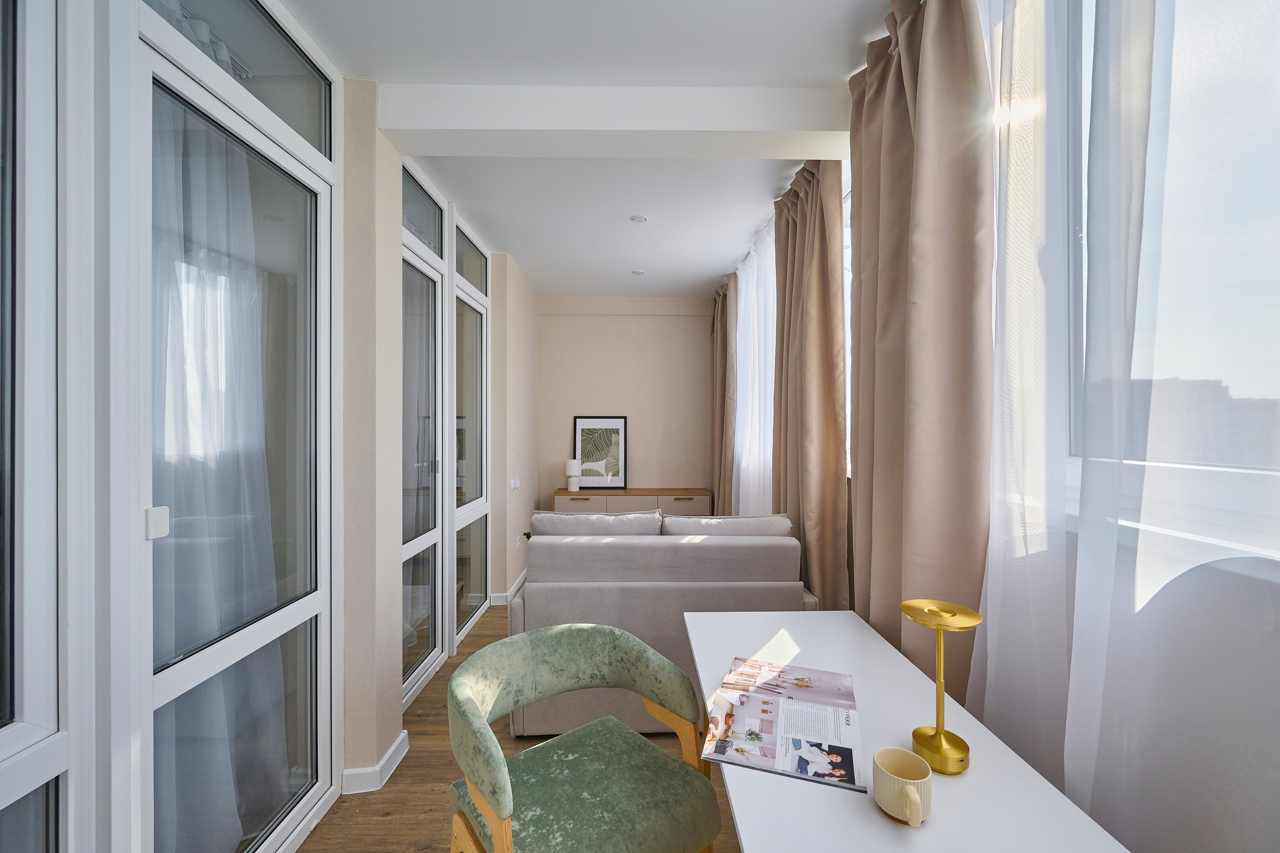 огромный балкон бежевые шторы светлый стол панорамные окна светлый зеленый стул 