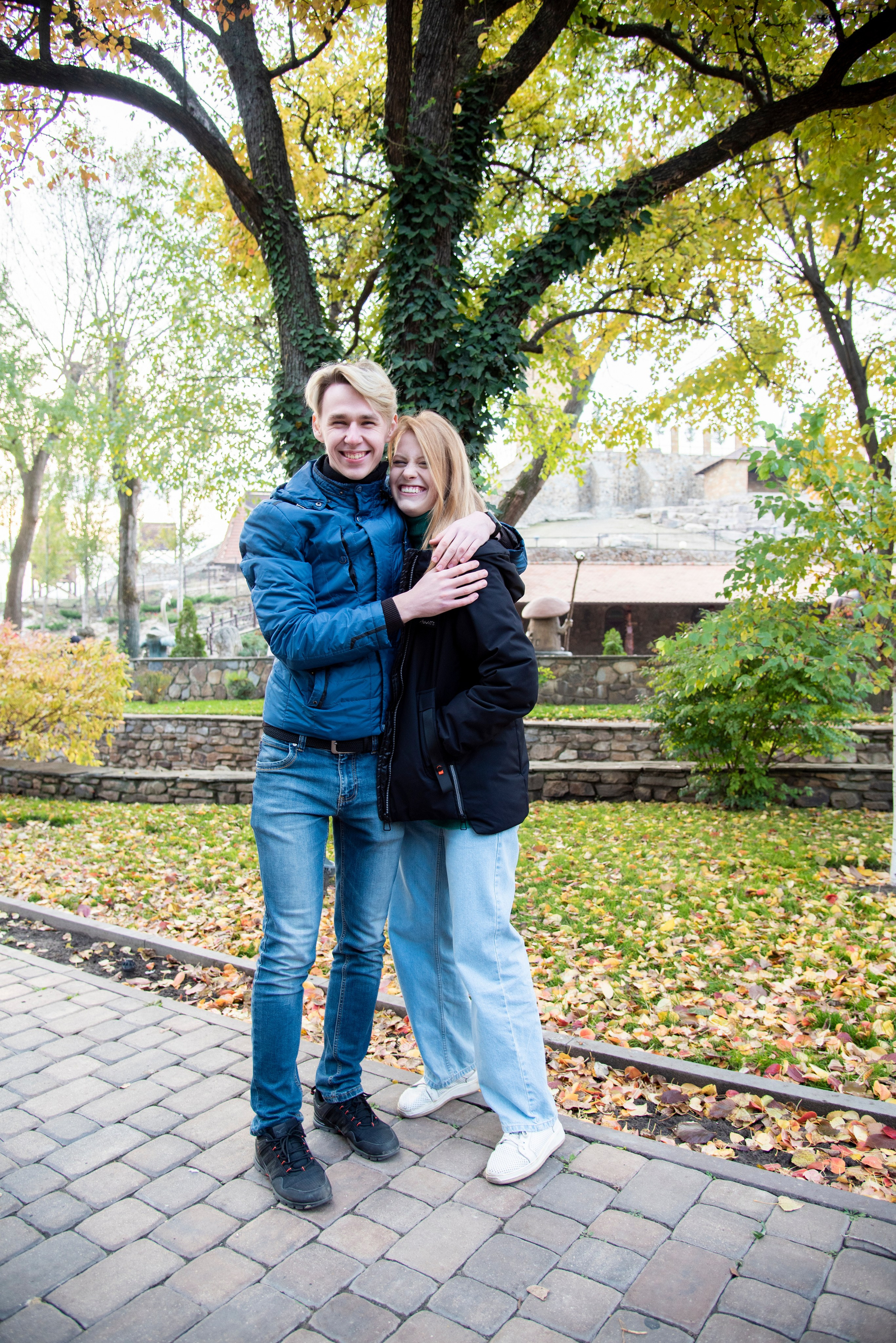 молодая девушка студентка. блондинка. длинные волосы. розово-зелёный свитер. парк Лога . осень брат с сестрой