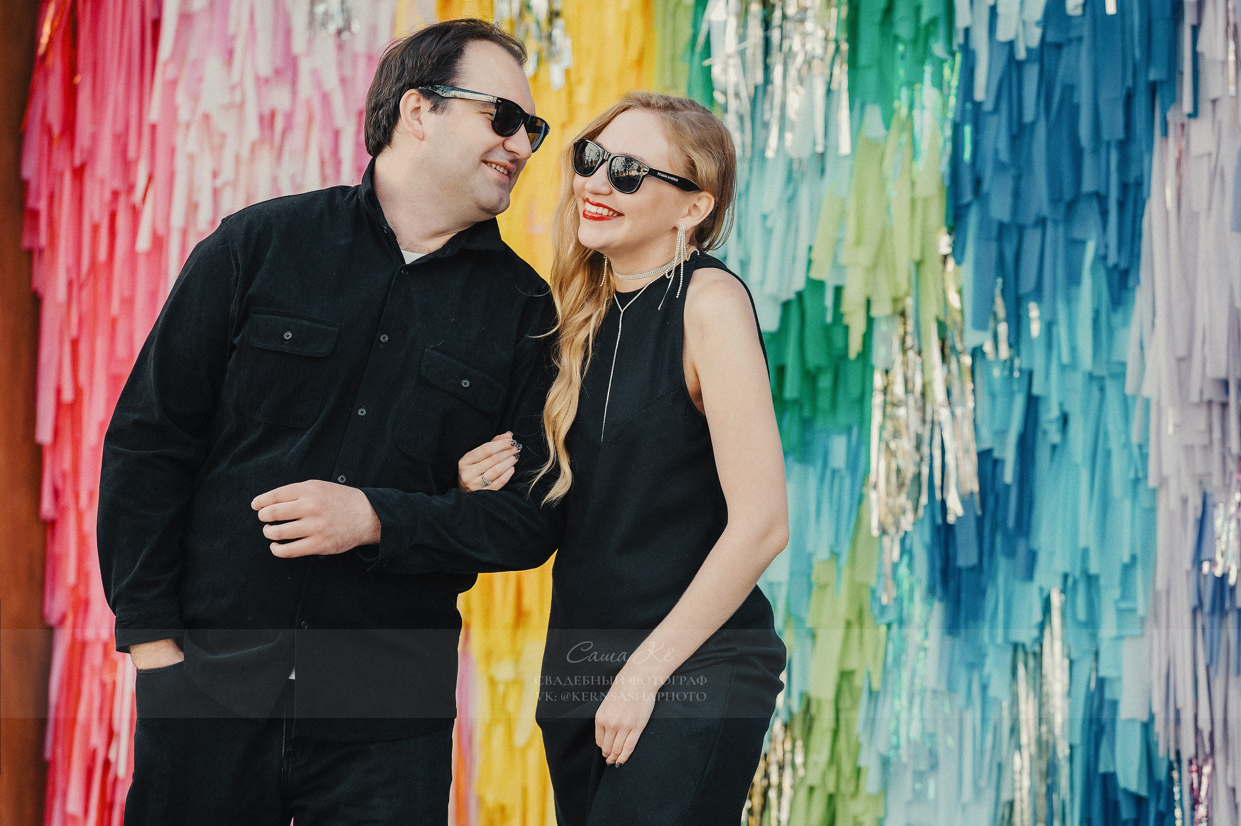 Невеста в белом платье смеётся рядом с женихом