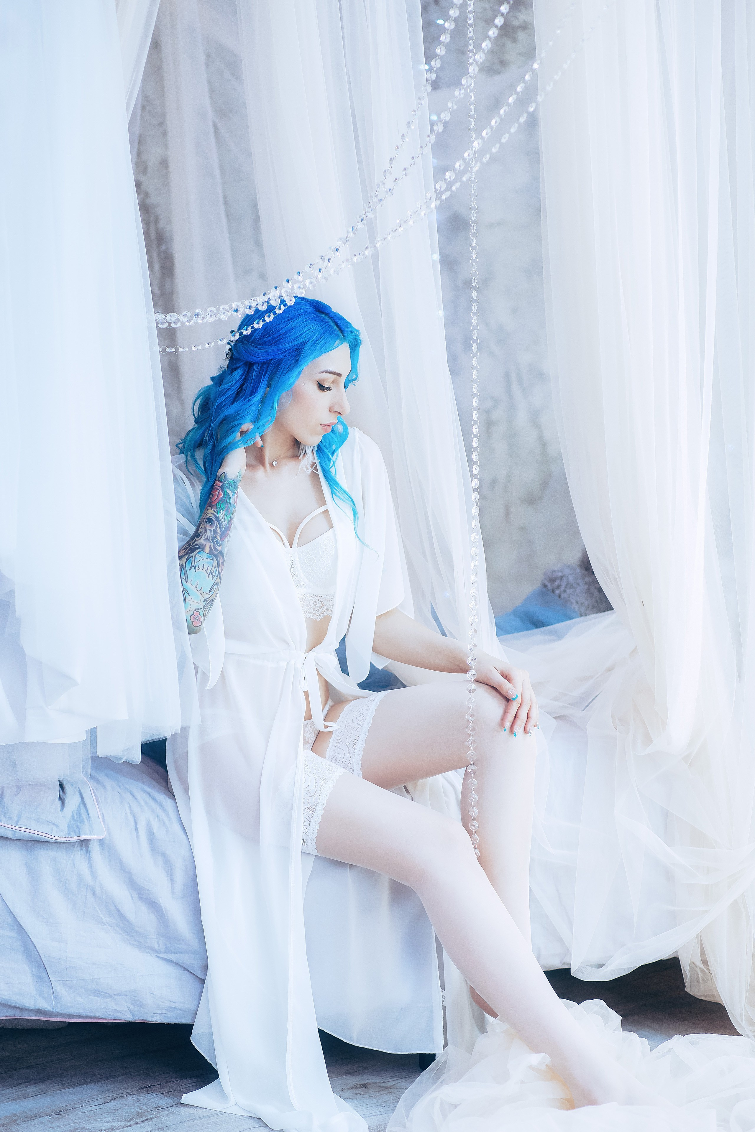 Невеста с цветными волосами в белом белье, прозрачной накидке и чулках