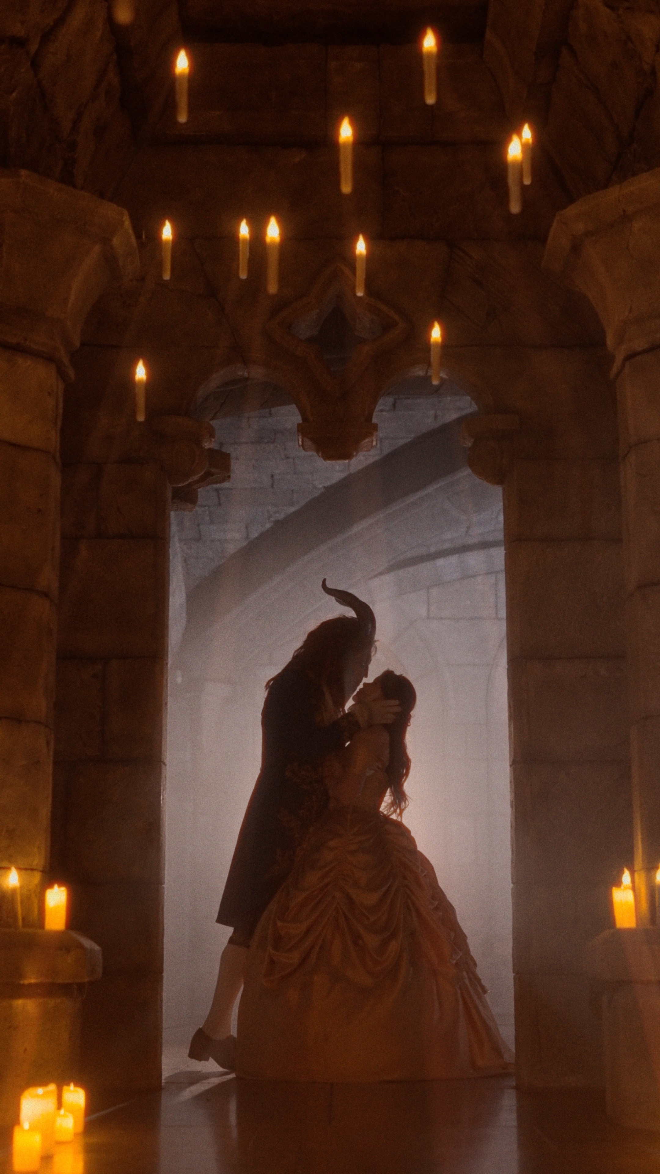 Женщина в роскошном платье, повёрнутая спиной к каменной арке, погружённой в мягкий свет свечей, подчеркивающий сказочность замка Гарибальди.
