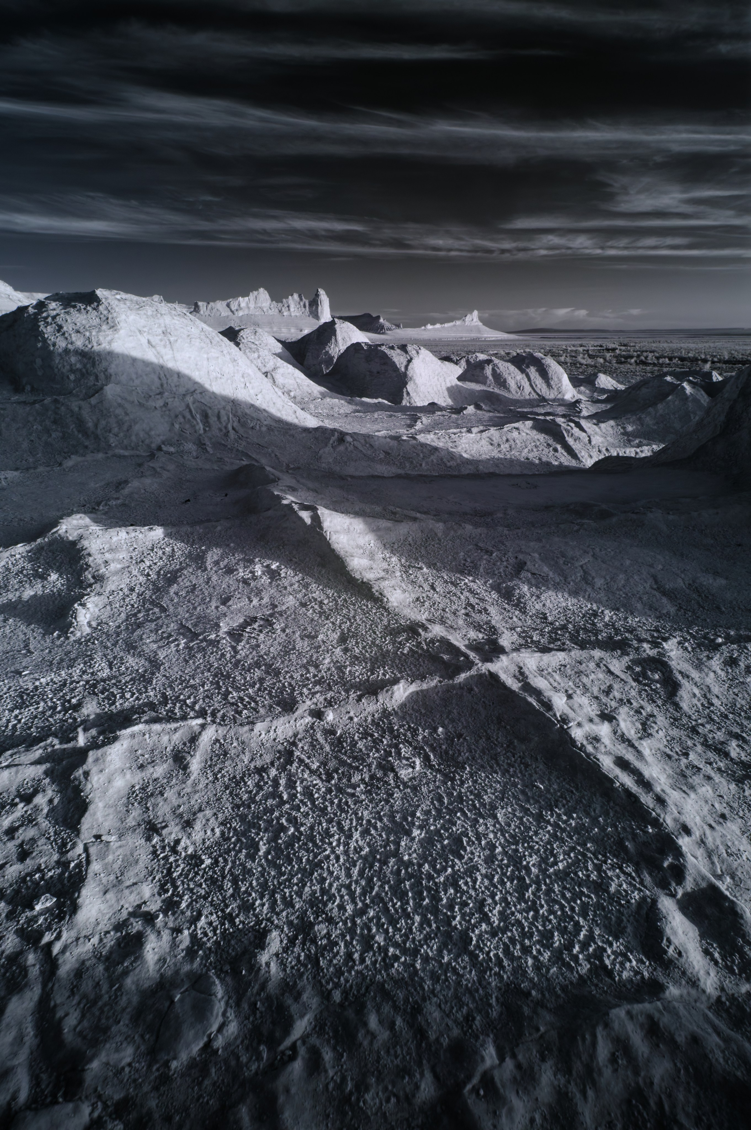 Трещины на переднем плане и Бозжира на заднем на закате