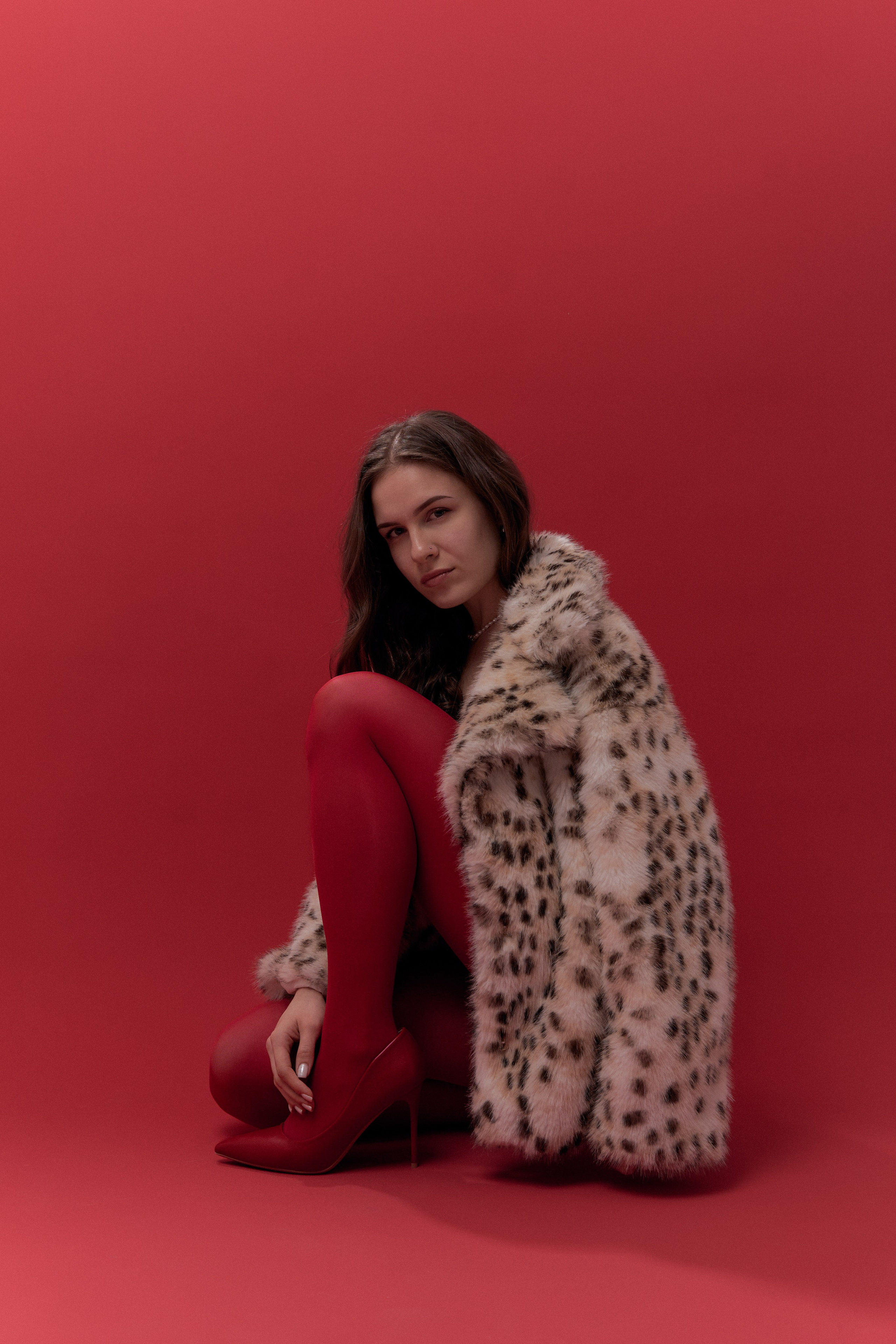 Фотосессия в студии на красном фоне, в леопардовой шубе, колготках. Фотограф Наталья Воронина Москва