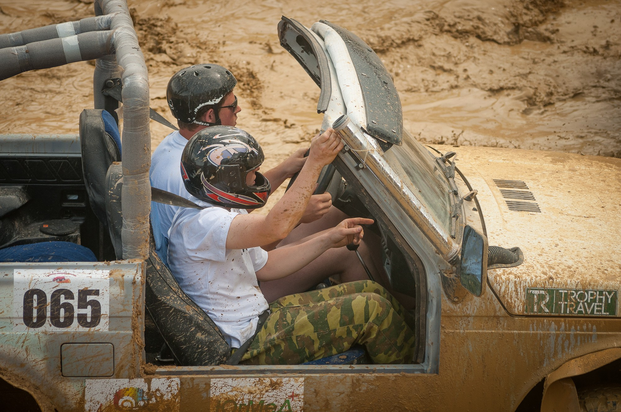 Водитель и штурман сидят в открытой кабине во время гонки