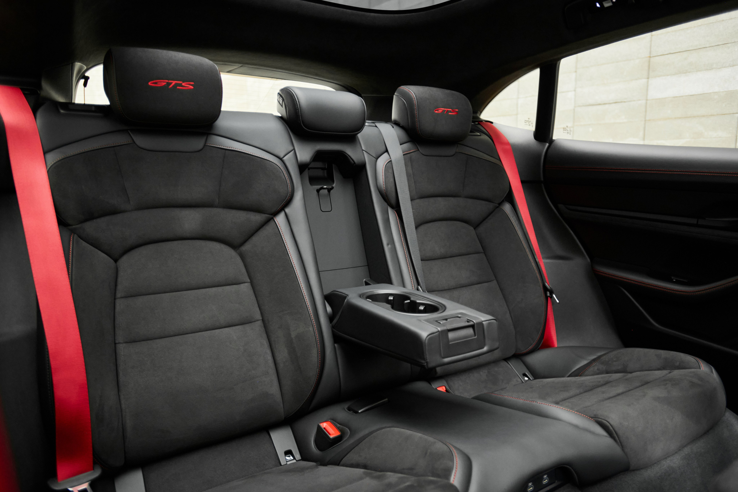 Задний ряд салона Porsche Taycan GTS с чёрной отделкой и красными ремнями