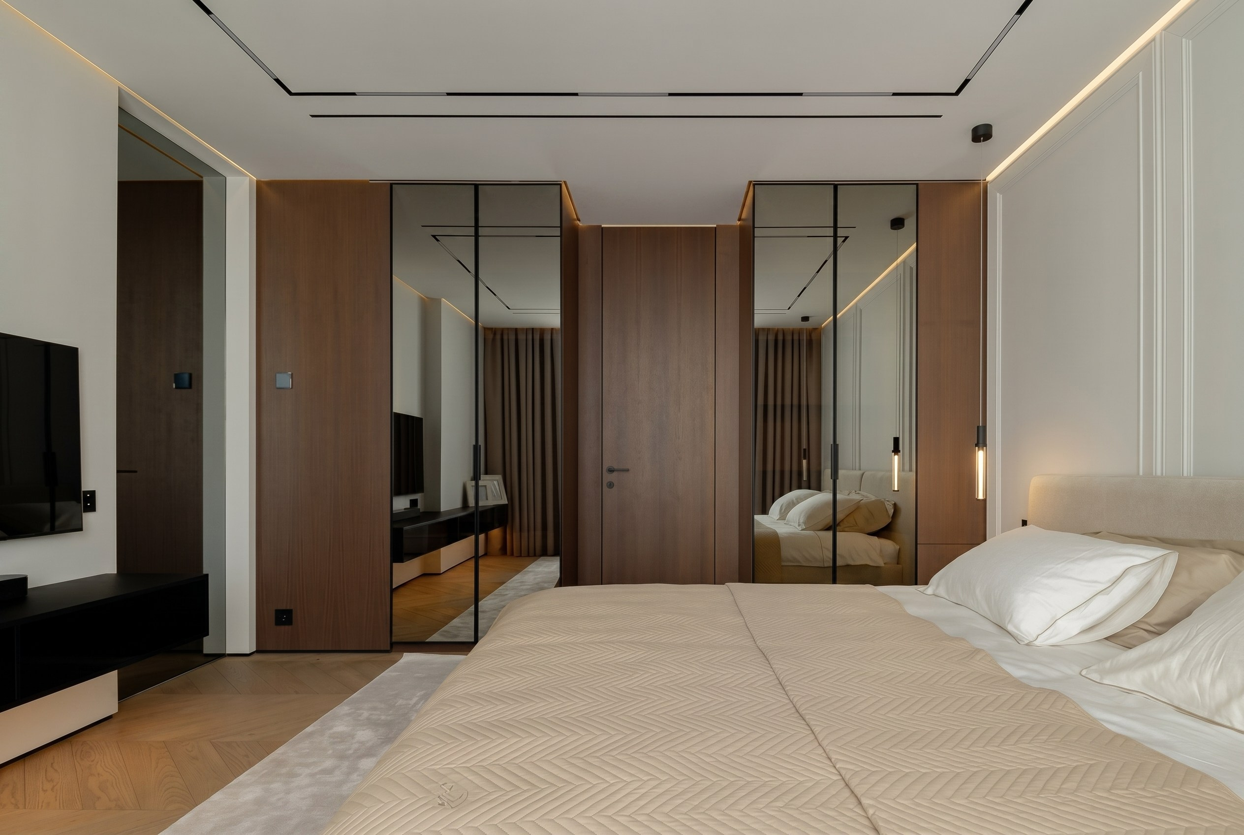 Планировка мастер-спальни в квартире 116 м² от Валерии Котович: симметричные зеркальные шкафы, шпонированные двери скрытого монтажа и современная ТВ-зона.