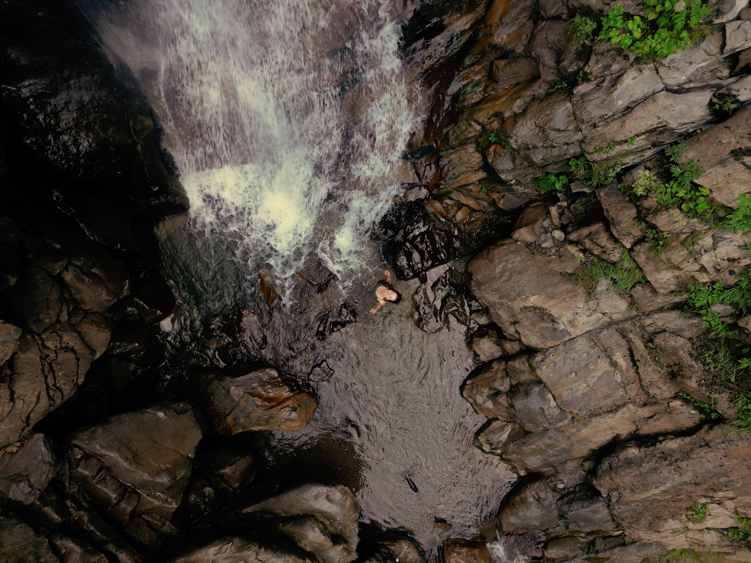 Вид сверху девушки стоящей сверху возле водопада