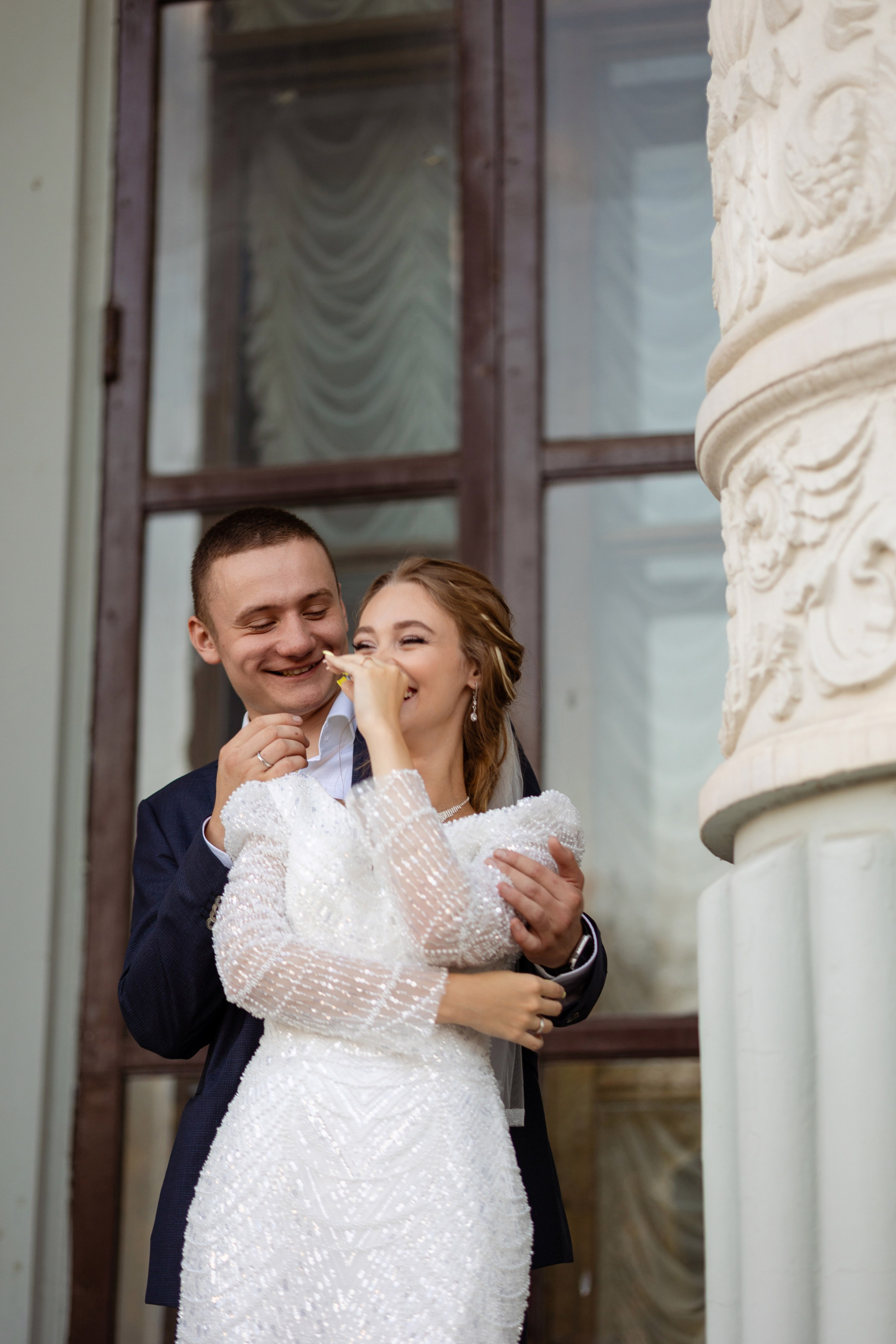 У молодых у колонны игривое настроение.