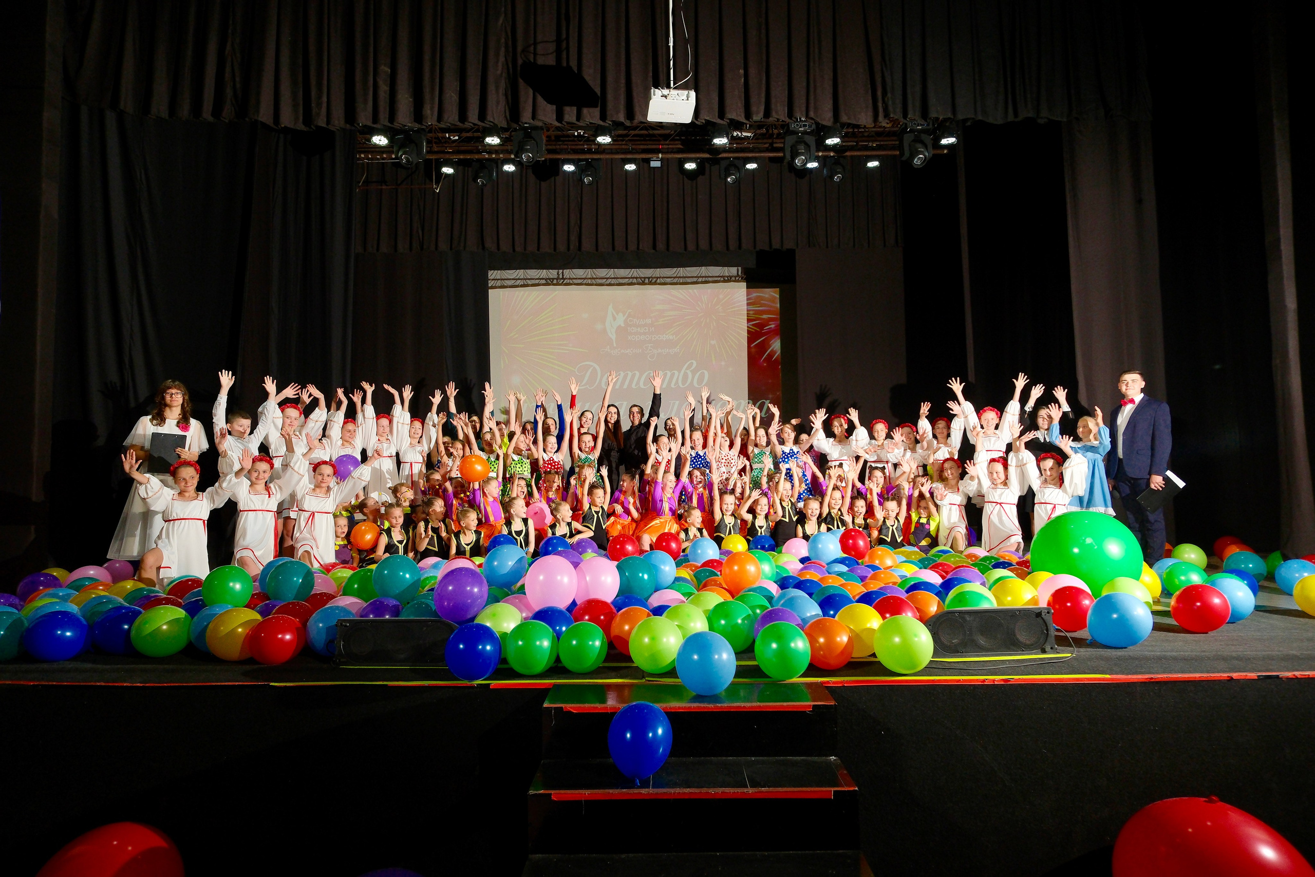 Юные танцоры ансамбля народного танца радостно улыбаются зрителям во время финального поклона на концерте