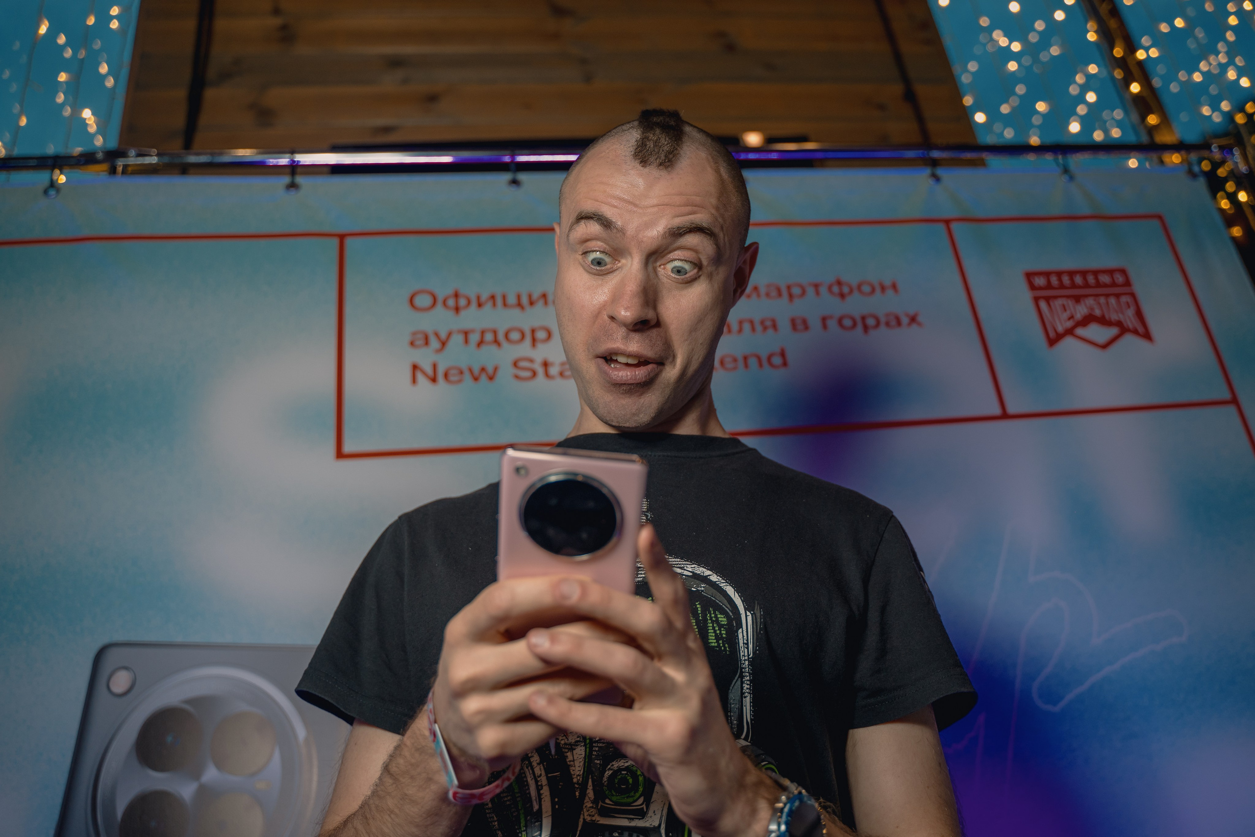 Эмоциональное фото участника на фоне банера с телефоном  Infinix Zero