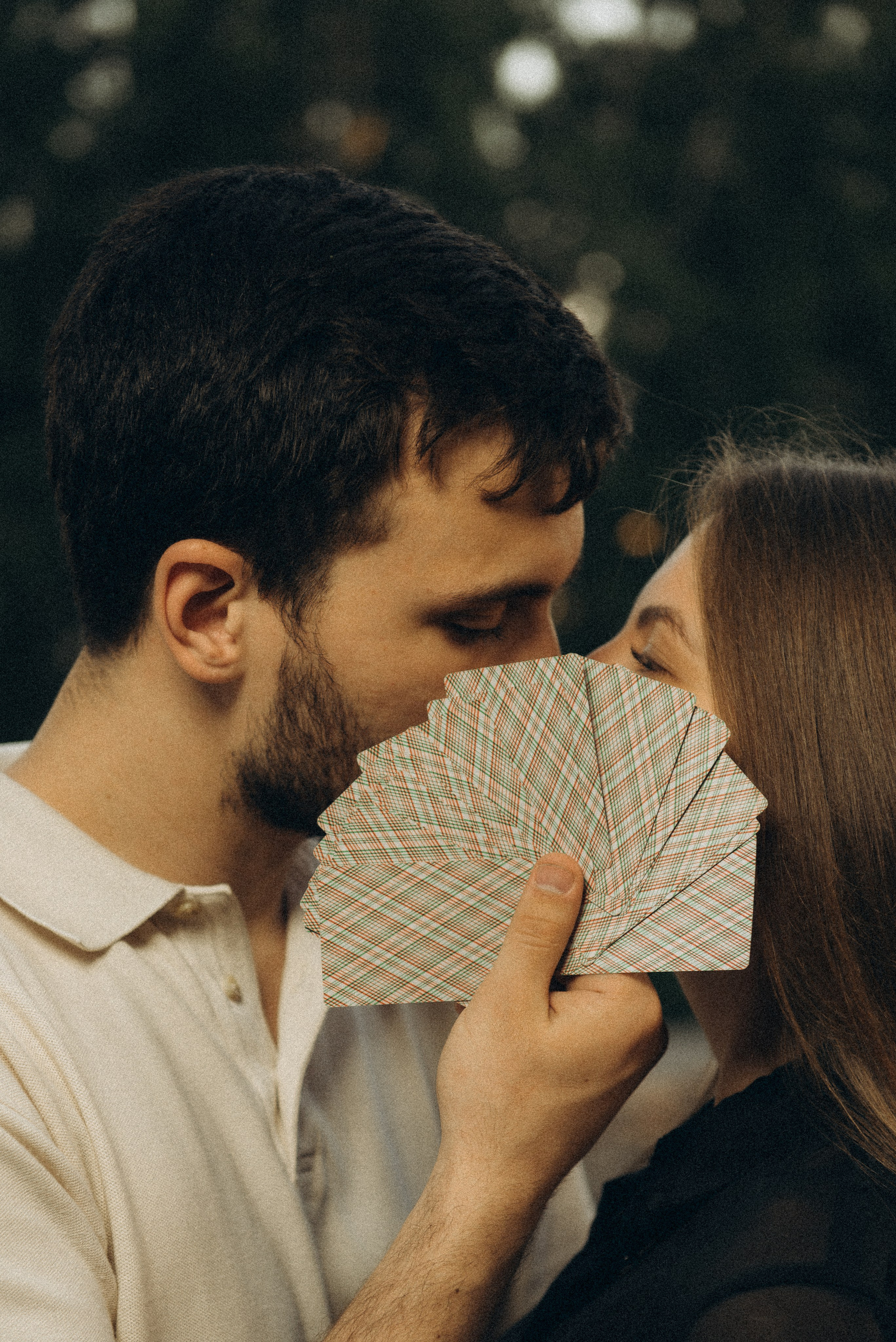 Оригинальная идея для Love Story: пара закрывает лица игральными картами. Фотосессия на Михайловской набережной в Новосибирске от Василия Дана.