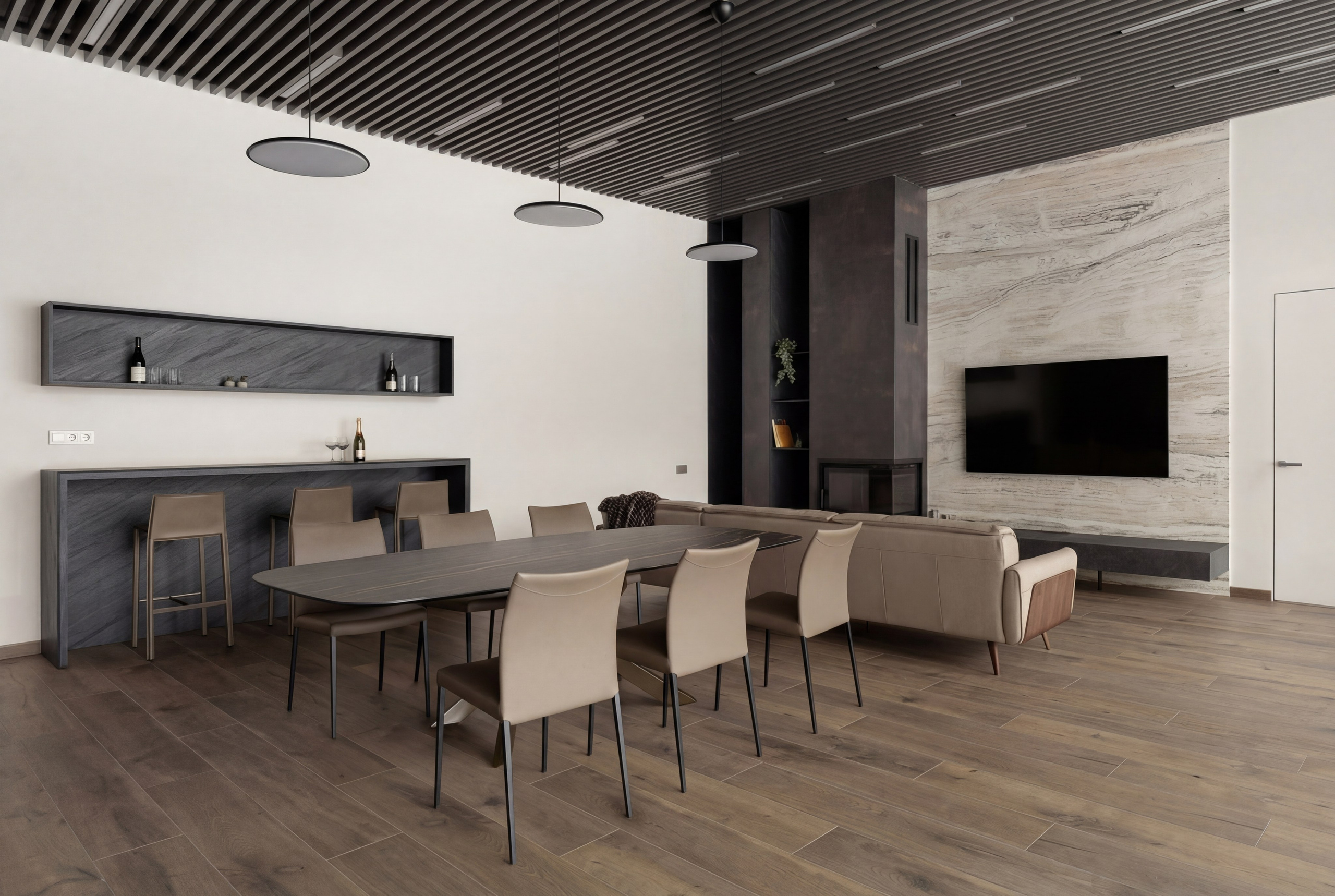 Интерьер столовой и гостиной с камином от Валерии Котович: обеденный стол на 8 персон, барная стойка, реечный потолок и ТВ-зона с отделкой из натурального камня в доме у воды.