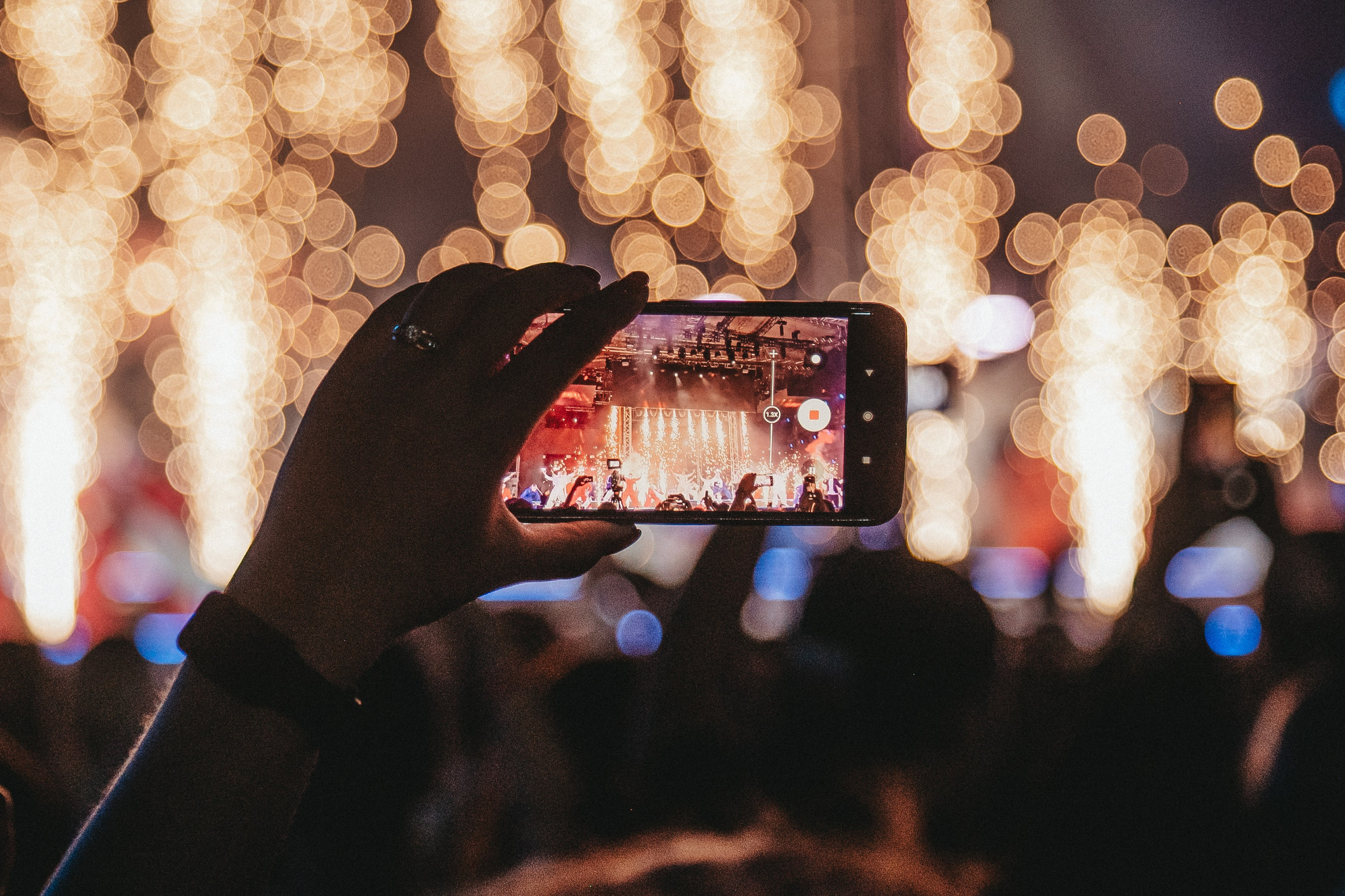 Контент для соц сетей с концерта: крупным планом телефон зрителя который снимает выступление артиста