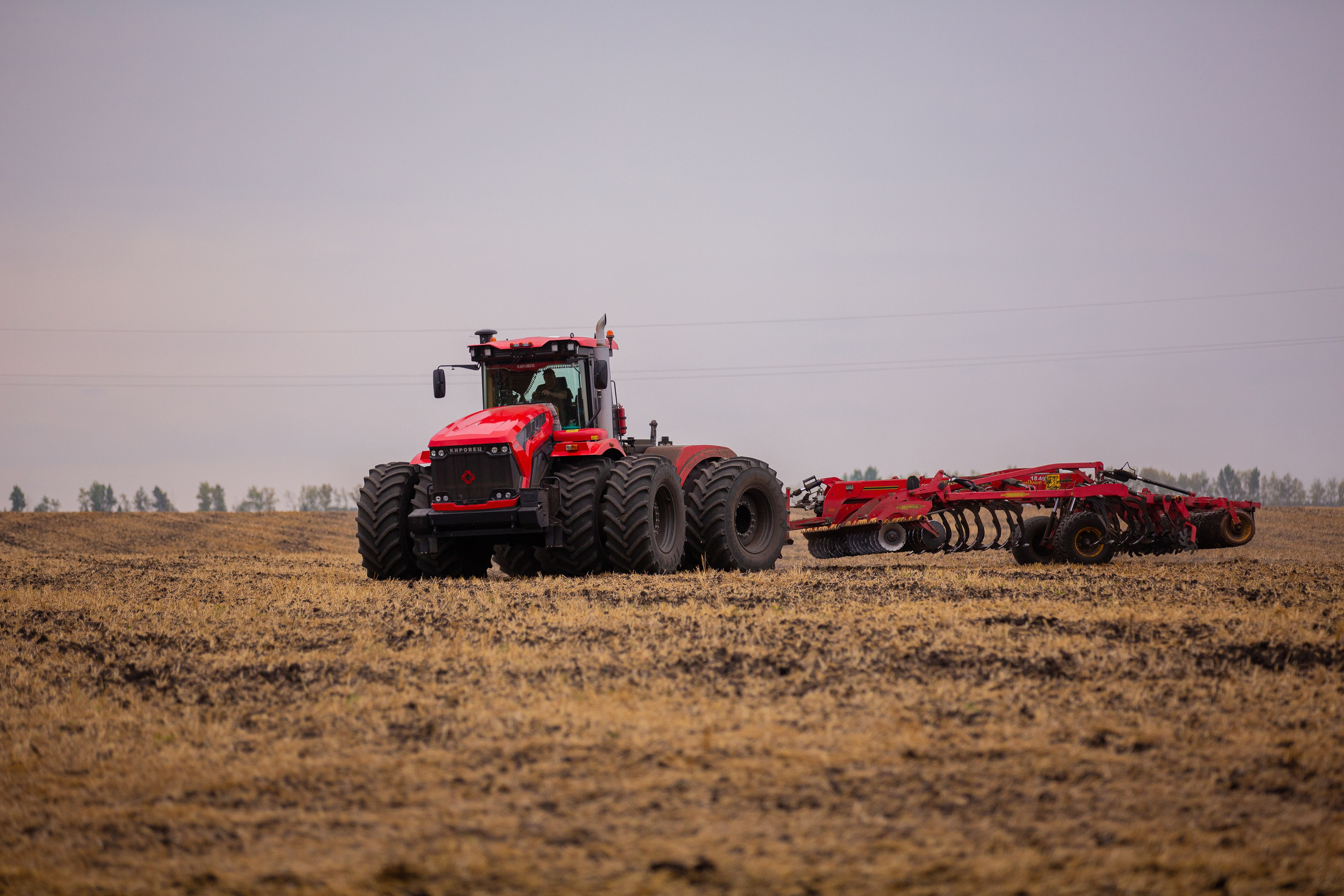 Трактор Кировец на пашне с бороной