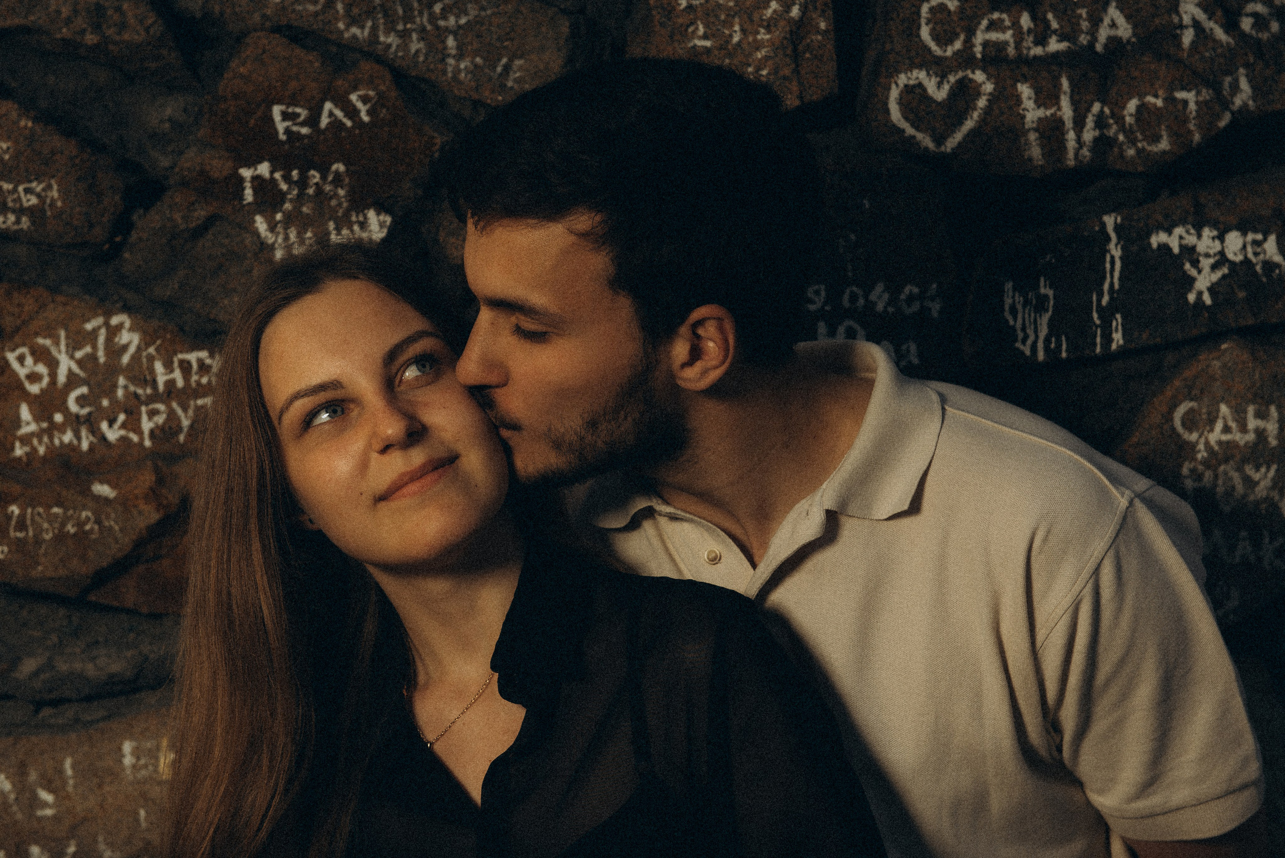 Нежный поцелуй в щеку на фоне стены с граффити. Романтическая прогулка у Речного вокзала в Новосибирске, съемка Василия Дана.